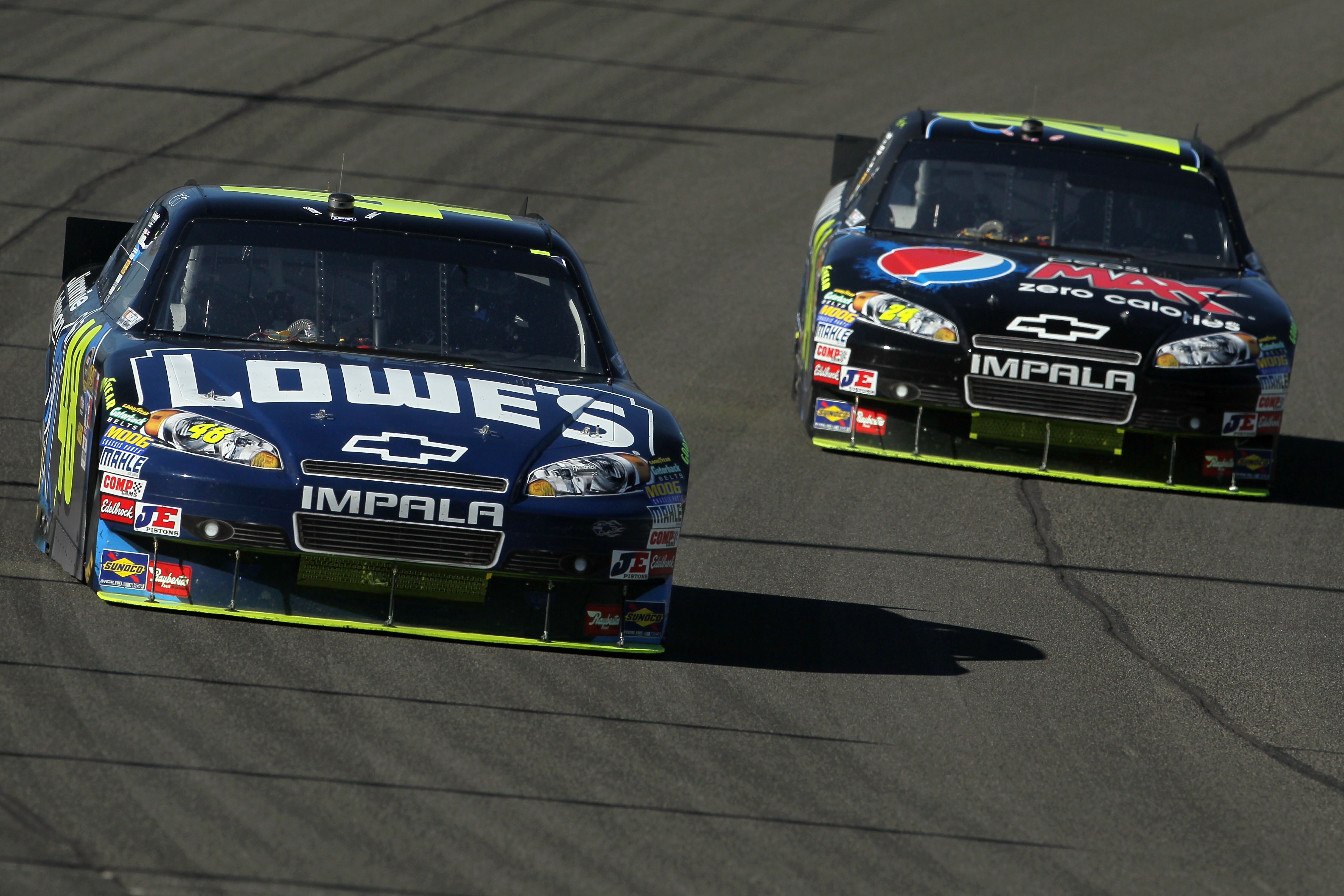 FONTANA, CA - OCTOBER 10:  Teammates Jimmie Johnson, driver of the #48 Lowe's/Jimmie Johnson Foundation Chevrolet, and Jeff Gordon, driver of the #24 DuPont Chevrolet, race during the NASCAR Sprint Cup Series Pepsi Max 400 on October 10, 2010 in Fontana,
