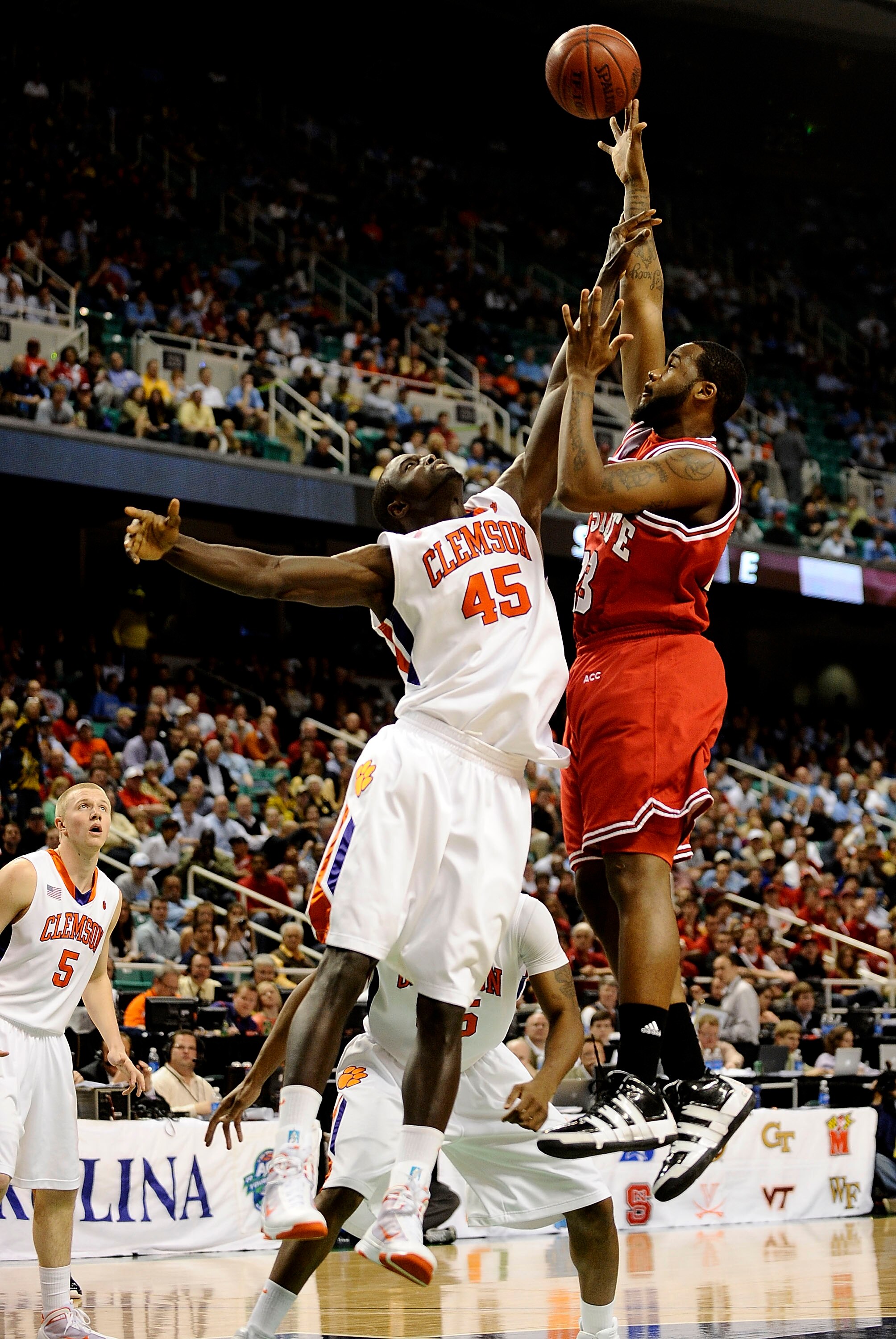 GREENSBORO, NC - MARCH 11:  Jerai Grant #45 of the Clemson Tigers guards Tracy Smith #23 of the NC State Wolfpack in their first round game in the 2010 ACC Men's Basketball Tournament at the Greensboro Coliseum on March 11, 2010 in Greensboro, North Carol