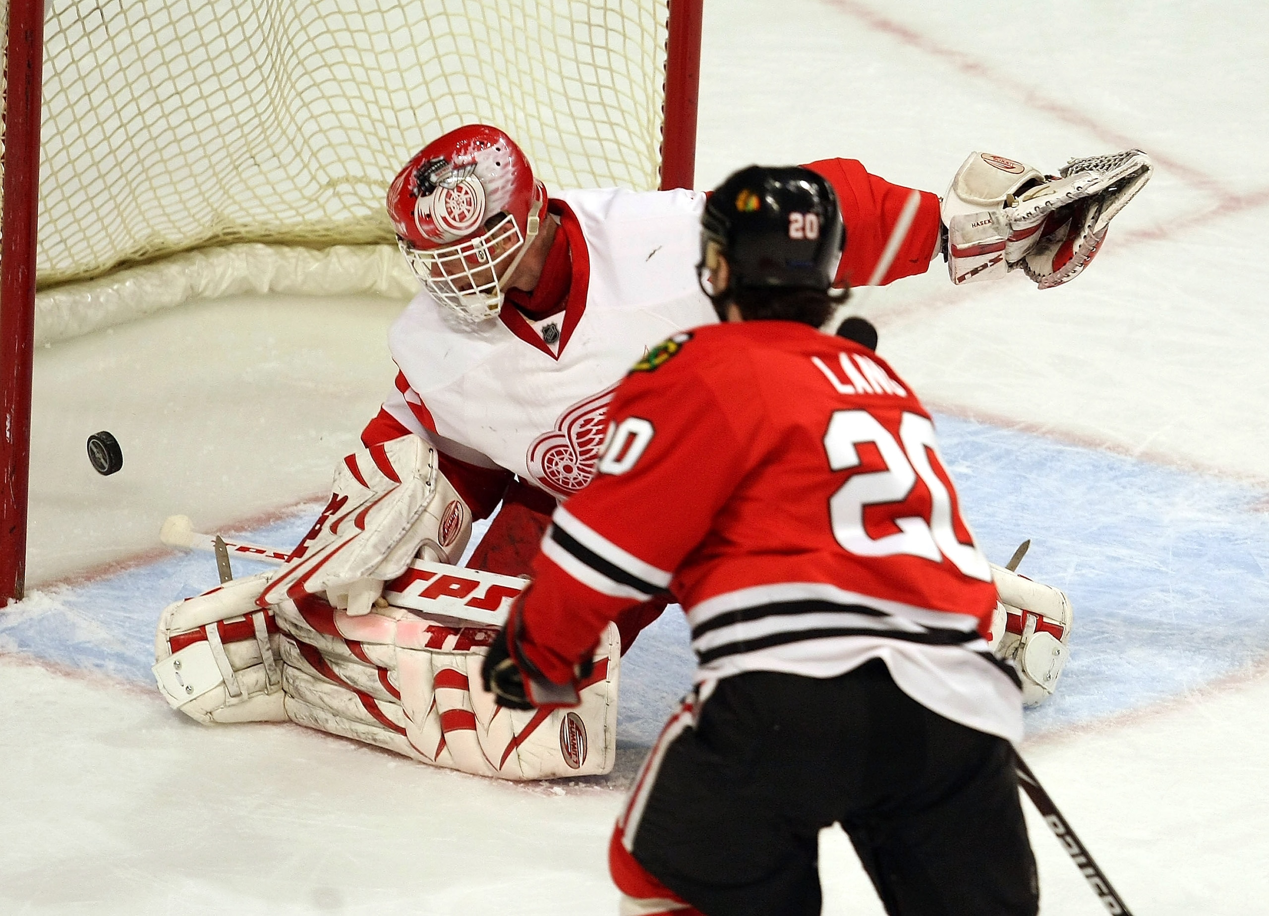 CHICAGO - APRIL 02: Robert Lang #20 of the Chicago Blackhawks slips the puck past Dominik Hasek #39 of the Detroit Red Wings for a first period goal on April 2, 2008 at the United Center in Chicago, Illinois. (Photo by Jonathan Daniel/Getty Images)