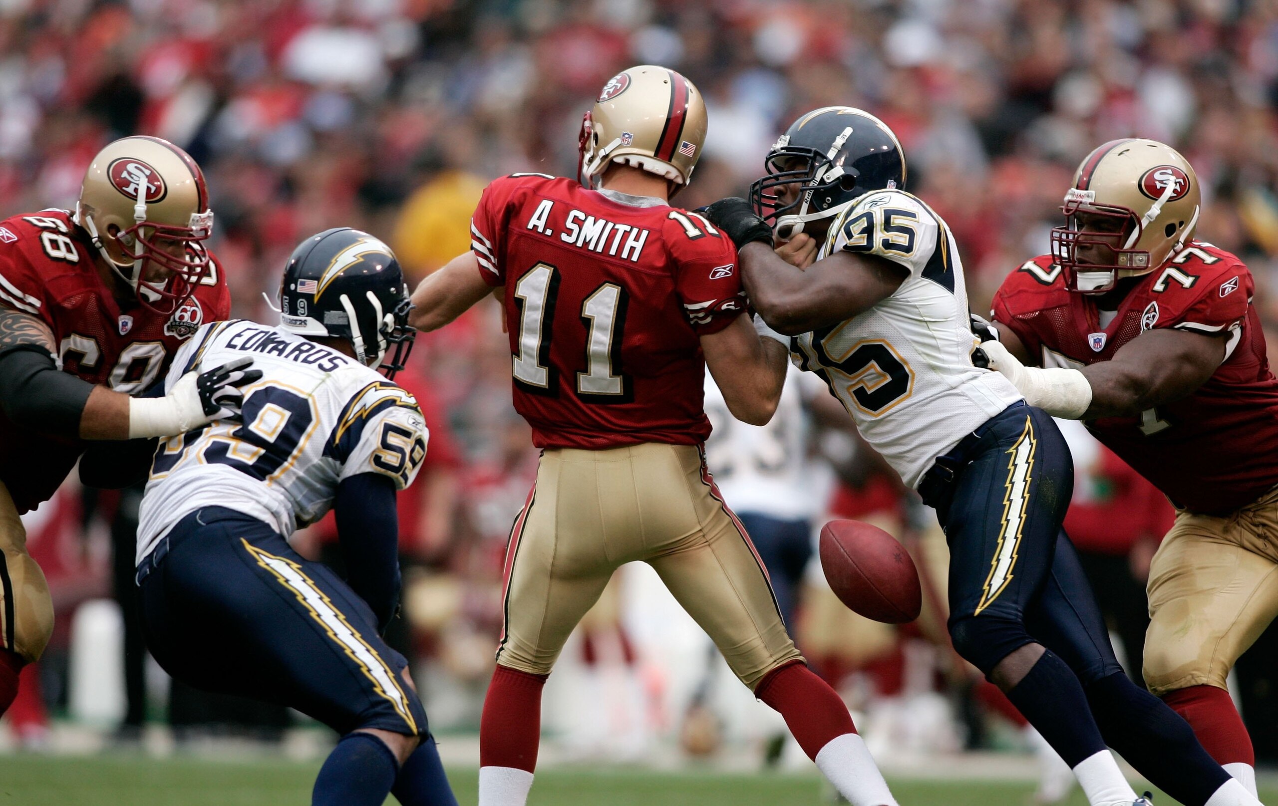 SAN FRANCISCO, CA - OCTOBER 15:  Quarterback Alex Smith #11 of the San Francisco 49ers fumbles the ball after being hit by Shaun Phillips #95 of the San Diego Chargers at Monster Park October 15, 2006 in San Francisco, California.  (Photo by Jonathan Ferr