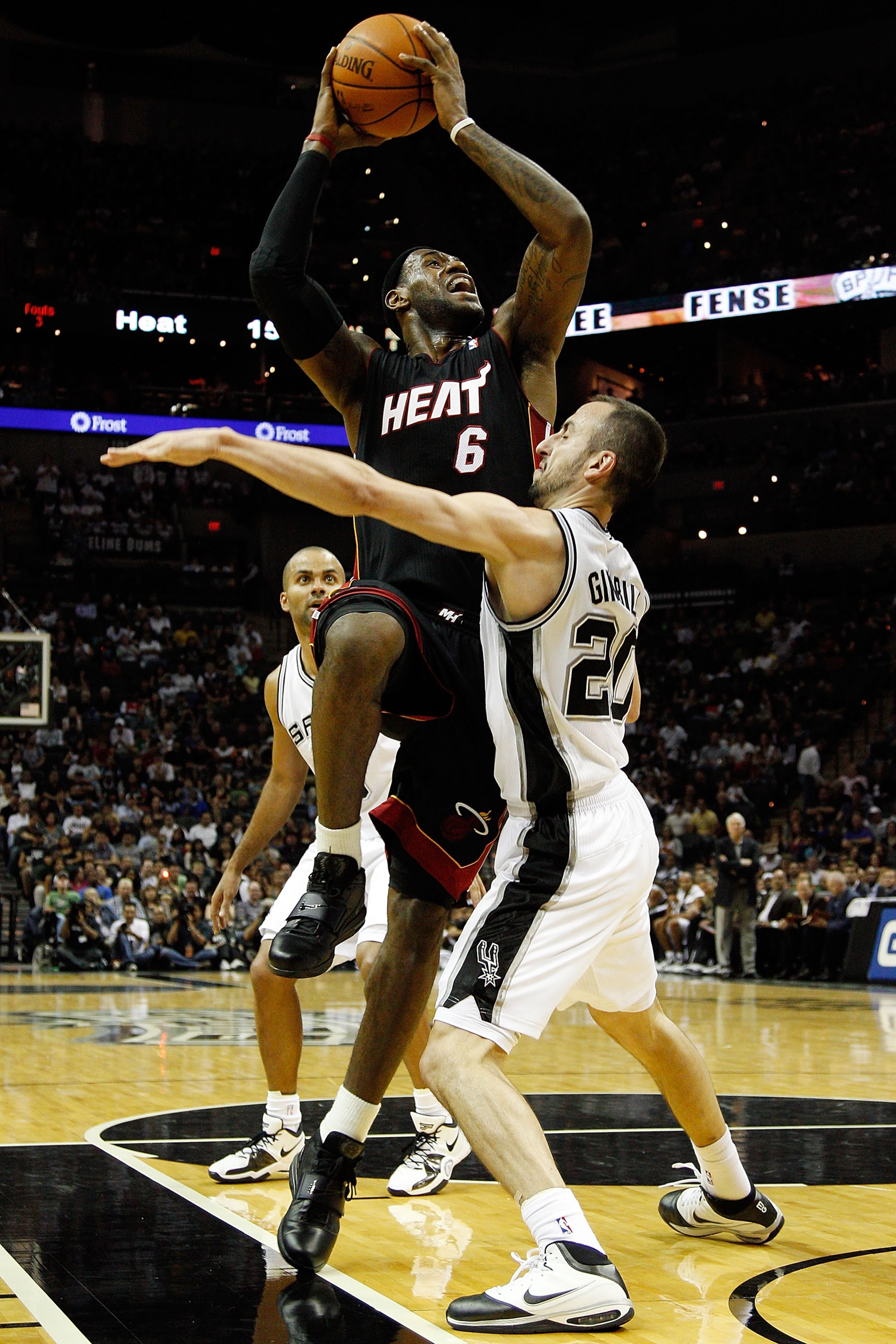 SAN ANTONIO - OCTOBER 09:  LeBron James #6 of the Miami Heat makes a shot over Manu Ginobili #20 of the San Antonio Spurs at the AT&T Center on October 9, 2010 in San Antonio, Texas.  NOTE TO USER: User expressly acknowledges and agrees that, by downloadi