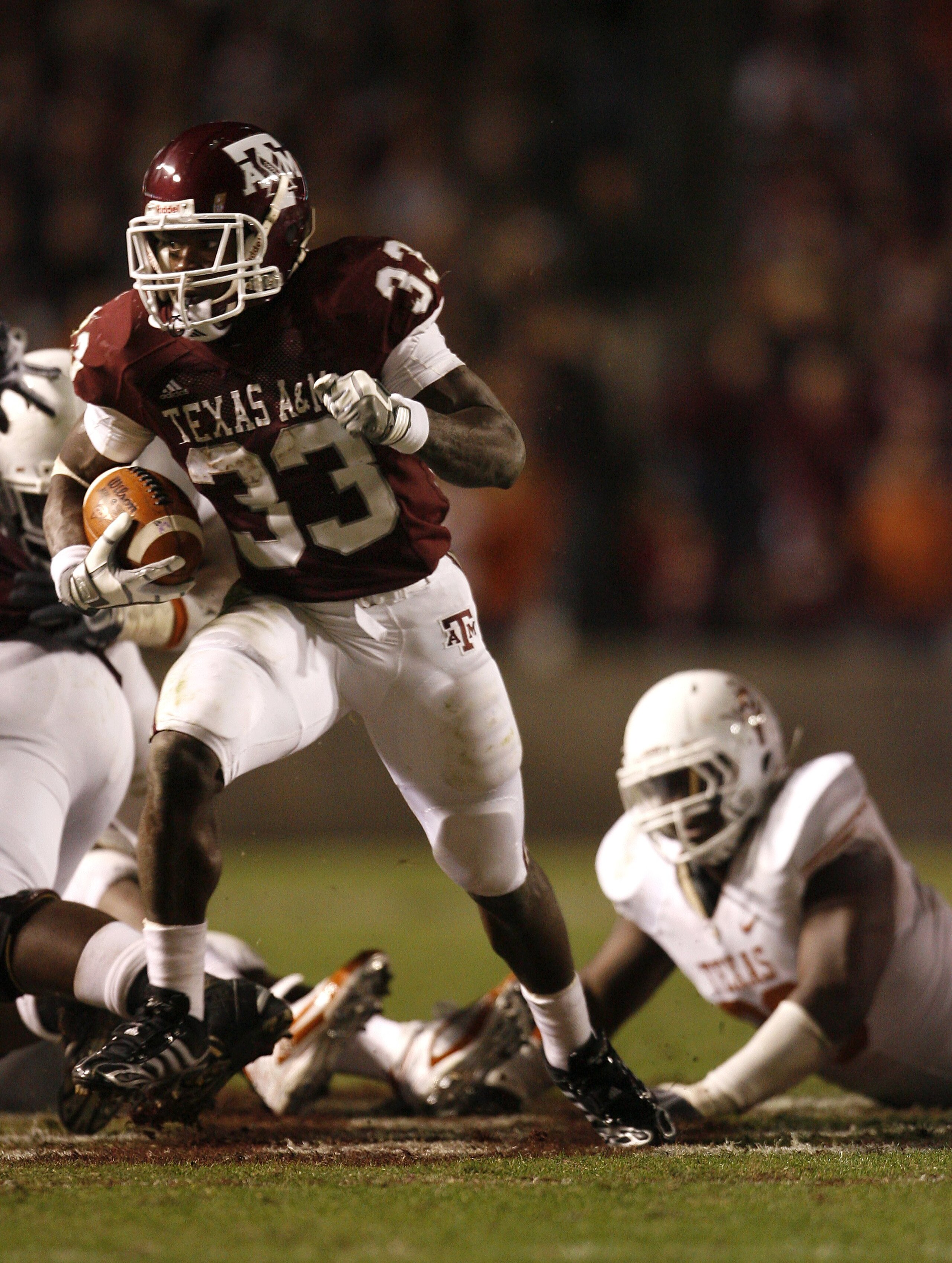 COLLEGE STATION, TX - NOVEMBER 26: Tailback Christine Michael #33 of the Texas A&M Aggies rushes for a gain against the Texas Longhorns defense in the second half at Kyle Field on November 26, 2009 in College Station, Texas. The Longhorns defeated the Agg
