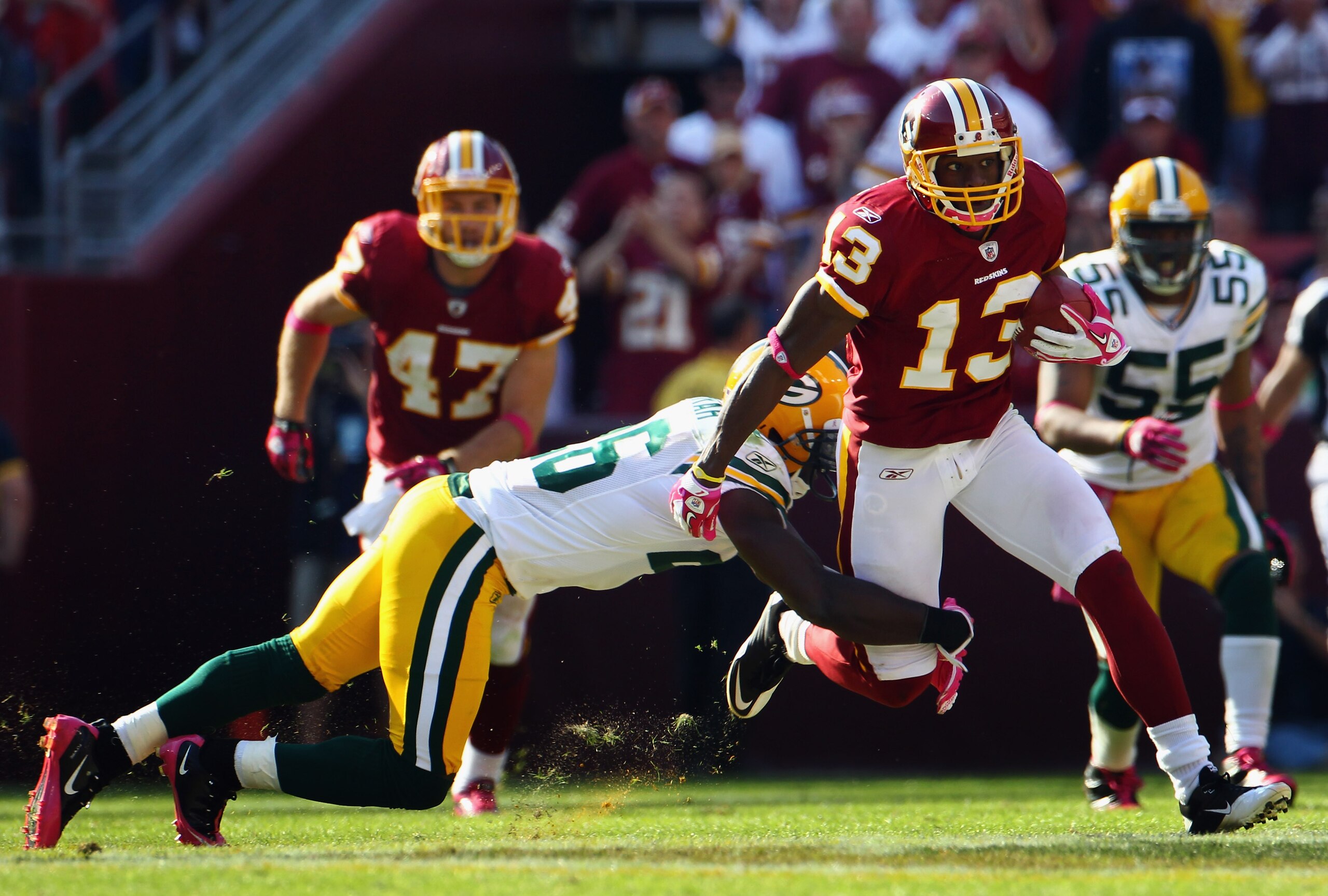 LANDOVER, MD - OCTOBER 10:  Wide receiver Anthony Armstrong #13 of the Washington Redskins runs after a catch while being tackled by defensive back Josh Bell #26 of the Green Bay Packers in the fourth quarter at FedExField on October 10, 2010 in Landover,