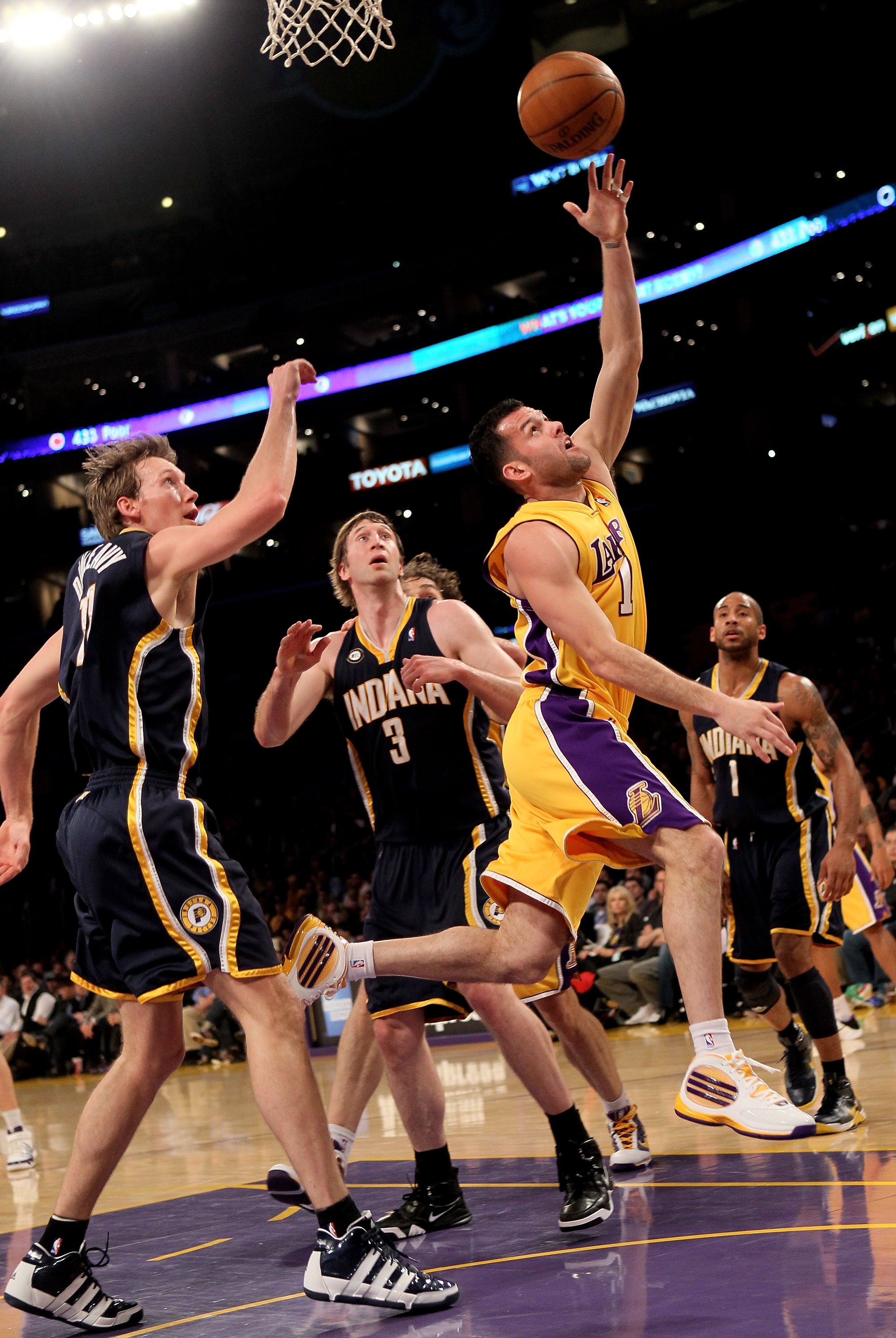 LOS ANGELES, CA - MARCH 02:  Jordan Farmar #1 of the Los Angeles Lakers scores on a reverse shot over Troy Murphy #3 and Mike Dunleavy #17 of the Indiana Pacers on March 2, 2010 at Staples Center in Los Angeles, California. The Lakers won 122-99.  NOTE TO