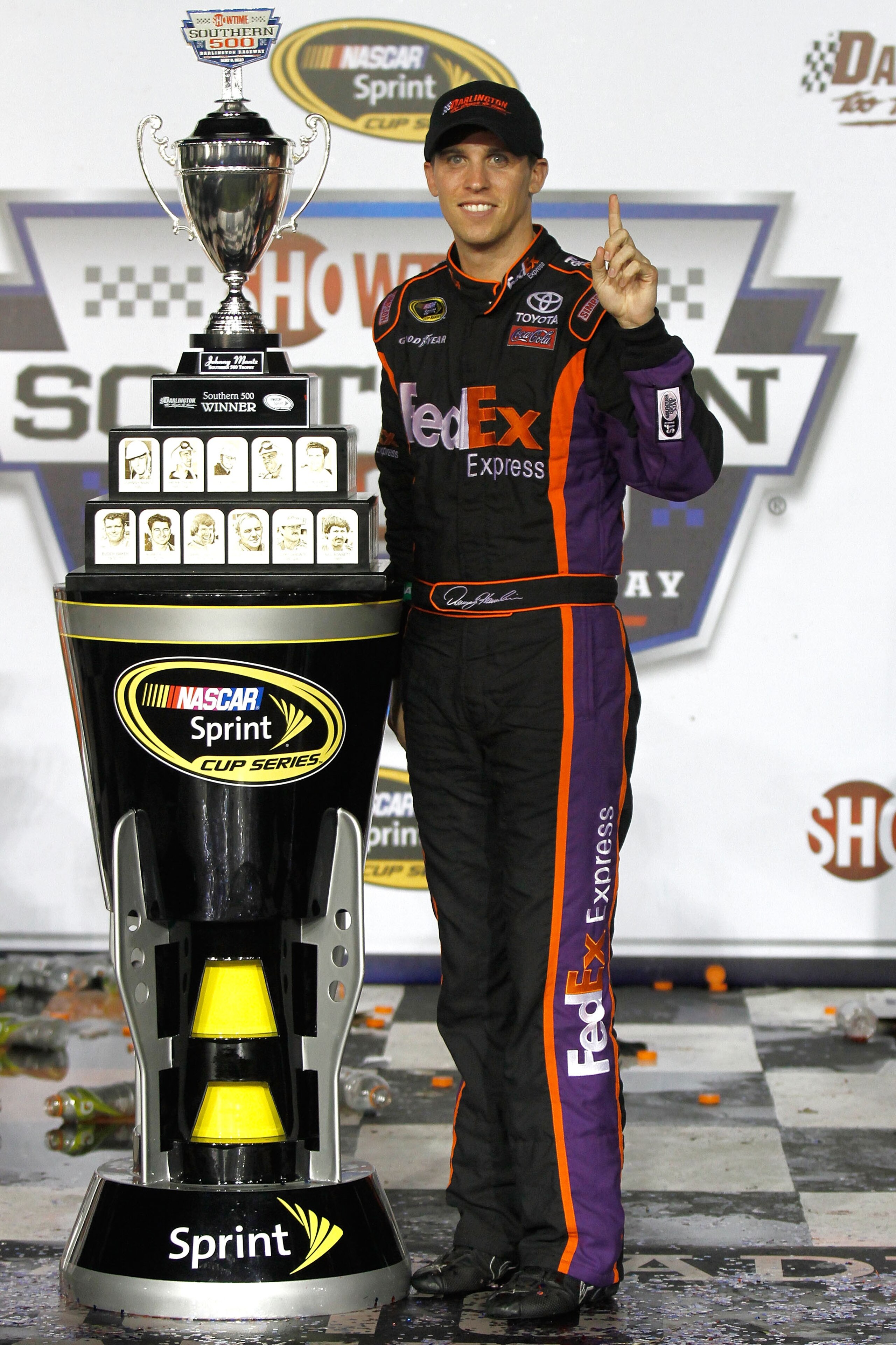 DARLINGTON, SC - MAY 08:  Denny Hamlin, driver of the #11 FedEx Express Toyota, celebrates with the trophy in victory lane in celebration of winning the NASCAR Sprint Cup series SHOWTIME Southern 500 at Darlington Raceway on May 8, 2010 in Darlington, Sou