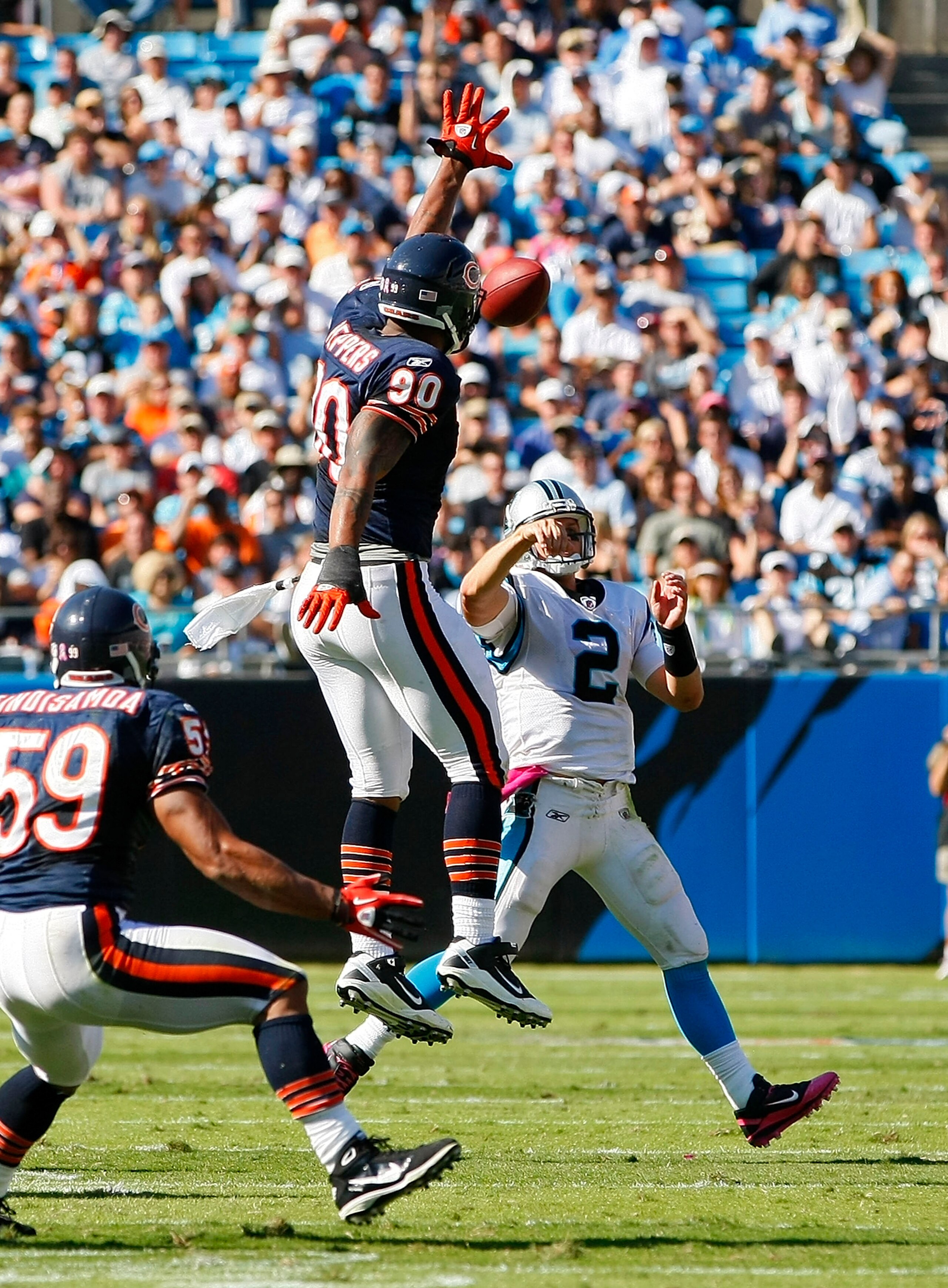 CHARLOTTE, NC - OCTOBER 10: Quarterback Jimmy Clausen #2 of the Carolina Panthers throws the ball over defensive end Julius Peppers #90 of the Chicago Bears at Bank of America Stadium on October 10, 2010 in Charlotte, North Carolina. (Photo by Geoff Burke