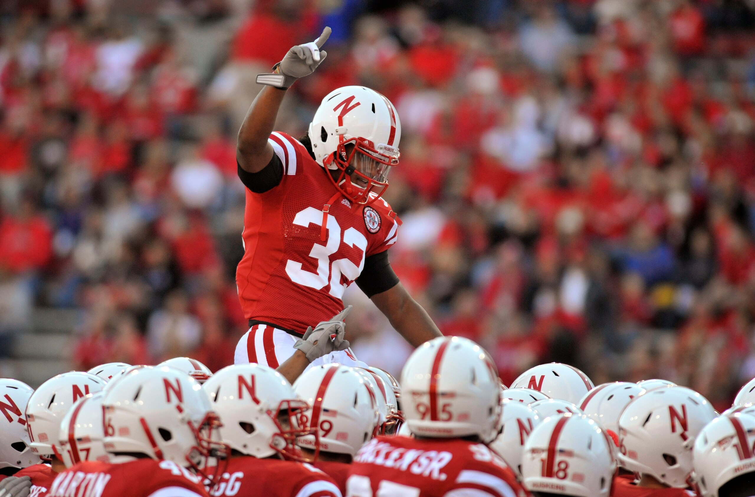 LINCOLN, NE - SEPTEMBER 25: Cornerback Marcus Mendoza #32 of the Nebraska Cornhuskers jumps on top of his teammates before the start of of their game against the South Dakota State Jackrabbits at Memorial Stadium on September 25, 2010 in Lincoln, Nebraska