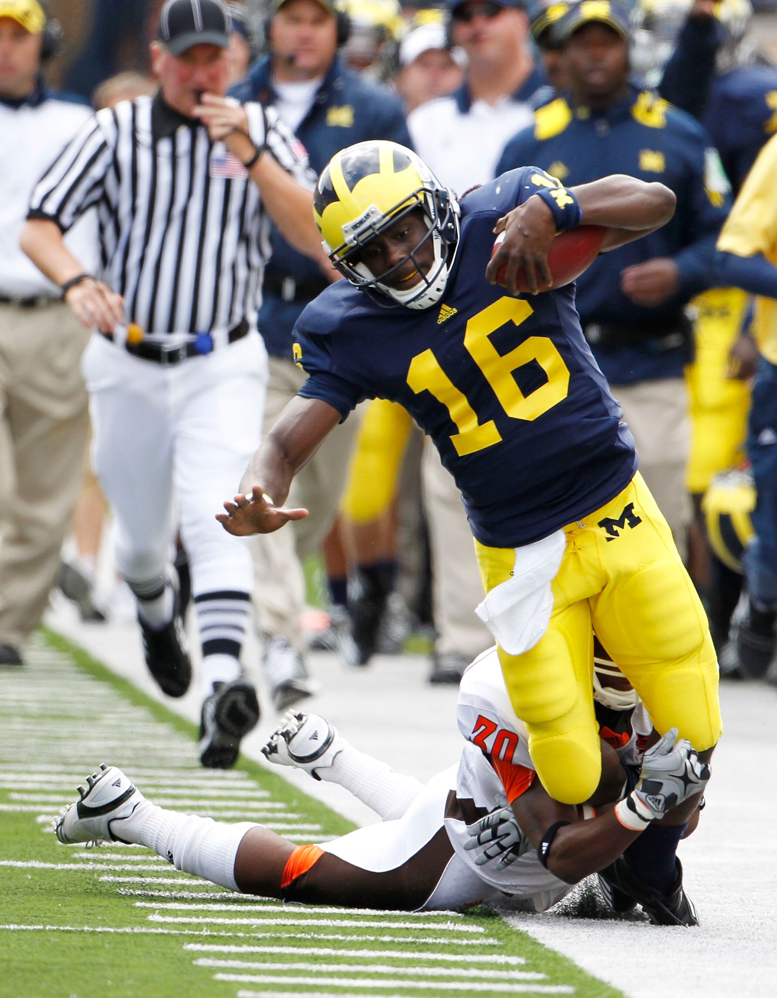 ANN ARBOR, MI - SEPTEMBER 25:  Cameron Truss #30 of Bowling Green tackles Denard Robison #16 of the Michigan Wolverines on September 25, 2010 at Michigan Stadium in Ann Arbor, Michigan. Robison left the game after this play with a reported leg injury.  (P