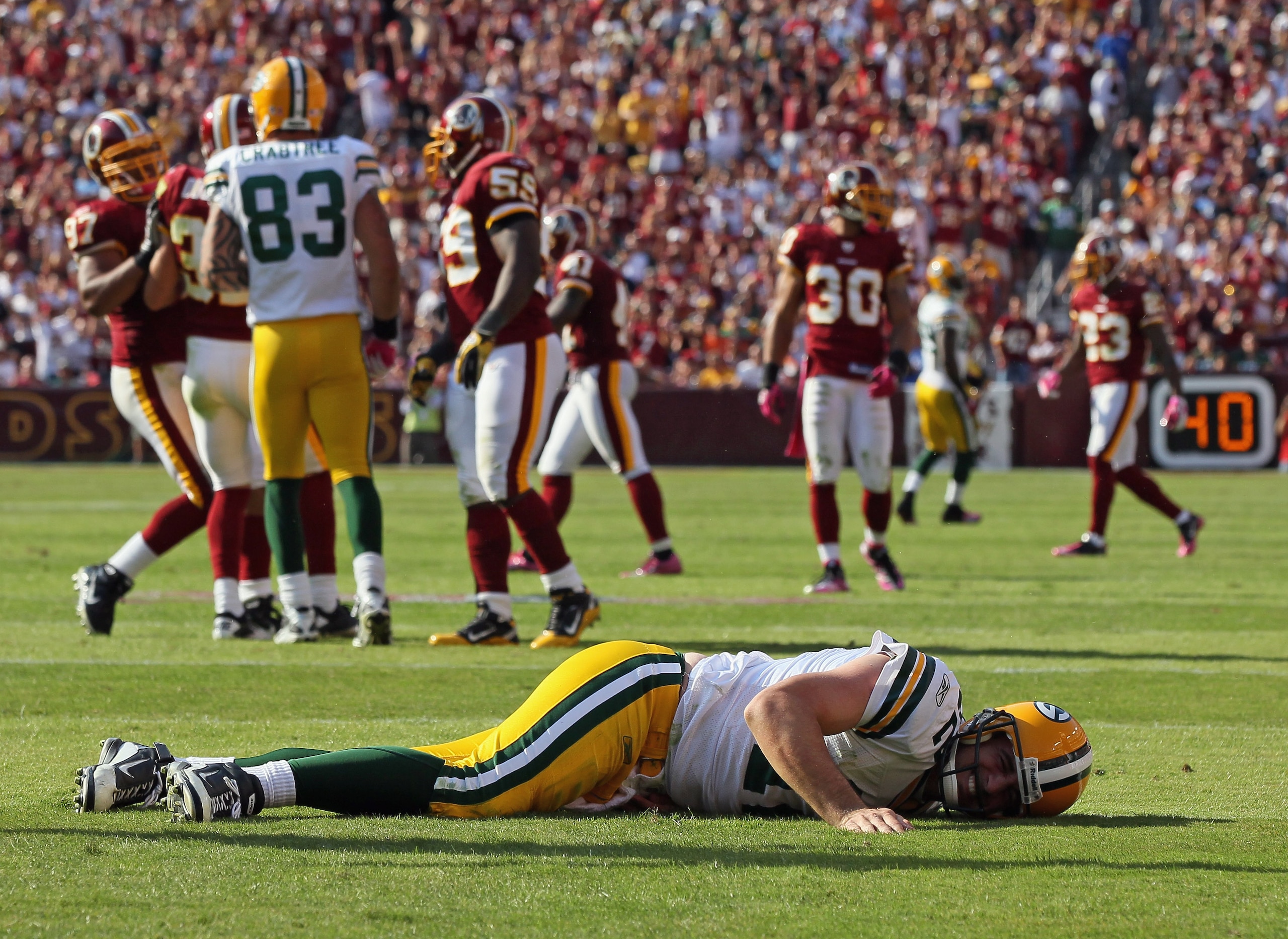 LANDOVER, MD - OCTOBER 10:  Aaron Rodgers #12 of the Green Bay Packers lays on the ground after a hard hit against the Washington Redskins in the fourth quarter at FedExField on October 10, 2010 in Landover, Maryland. The Redskins won the game in overtime