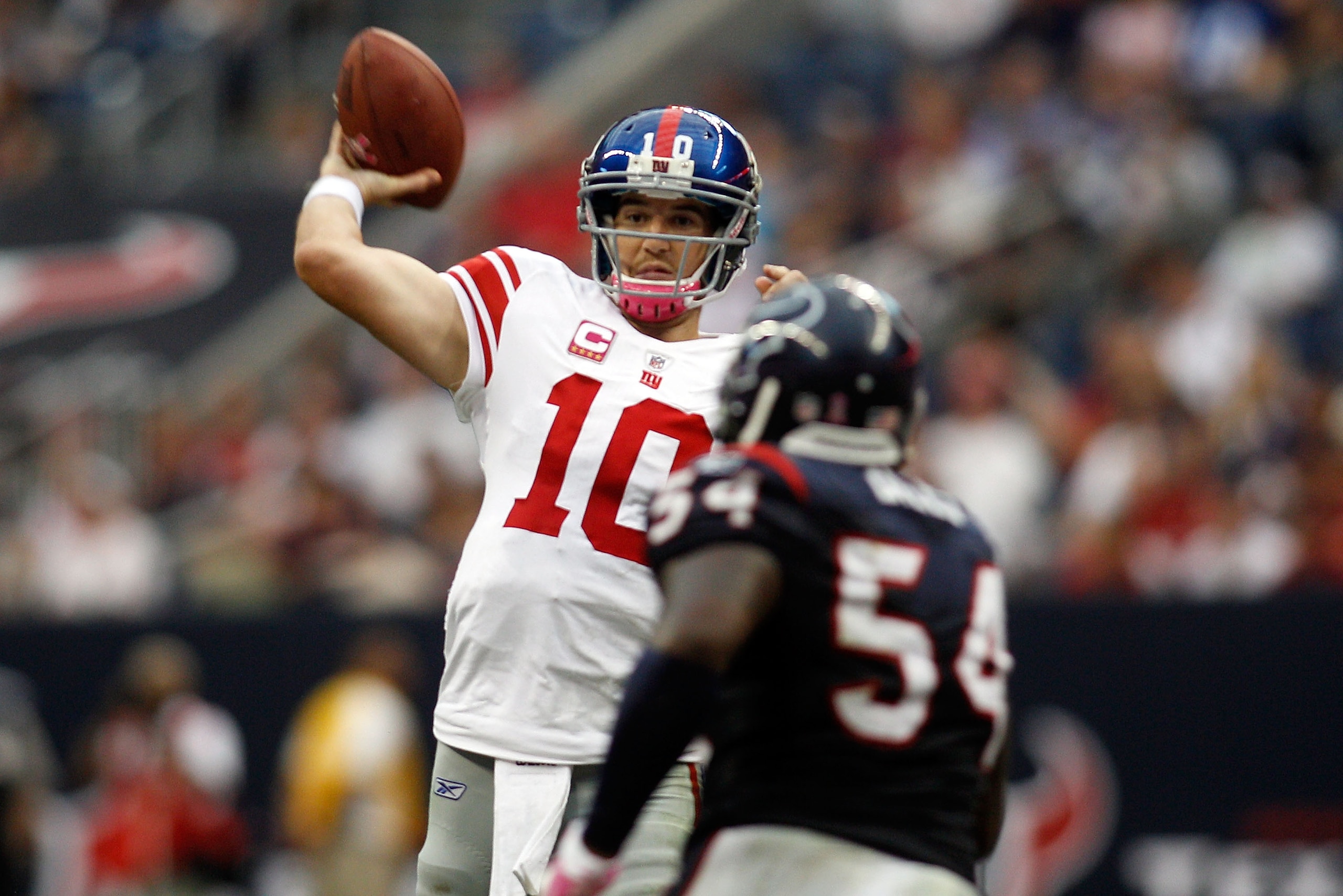 HOUSTON - OCTOBER 10:  Eli Manning #10 of the New York Giants throws a pass over Zac Diles #54 of  the Houston Texans at Reliant Stadium on October 10, 2010 in Houston, Texas.  The Giants defeated the Texans 34-10.  (Photo by Chris Graythen/Getty Images)