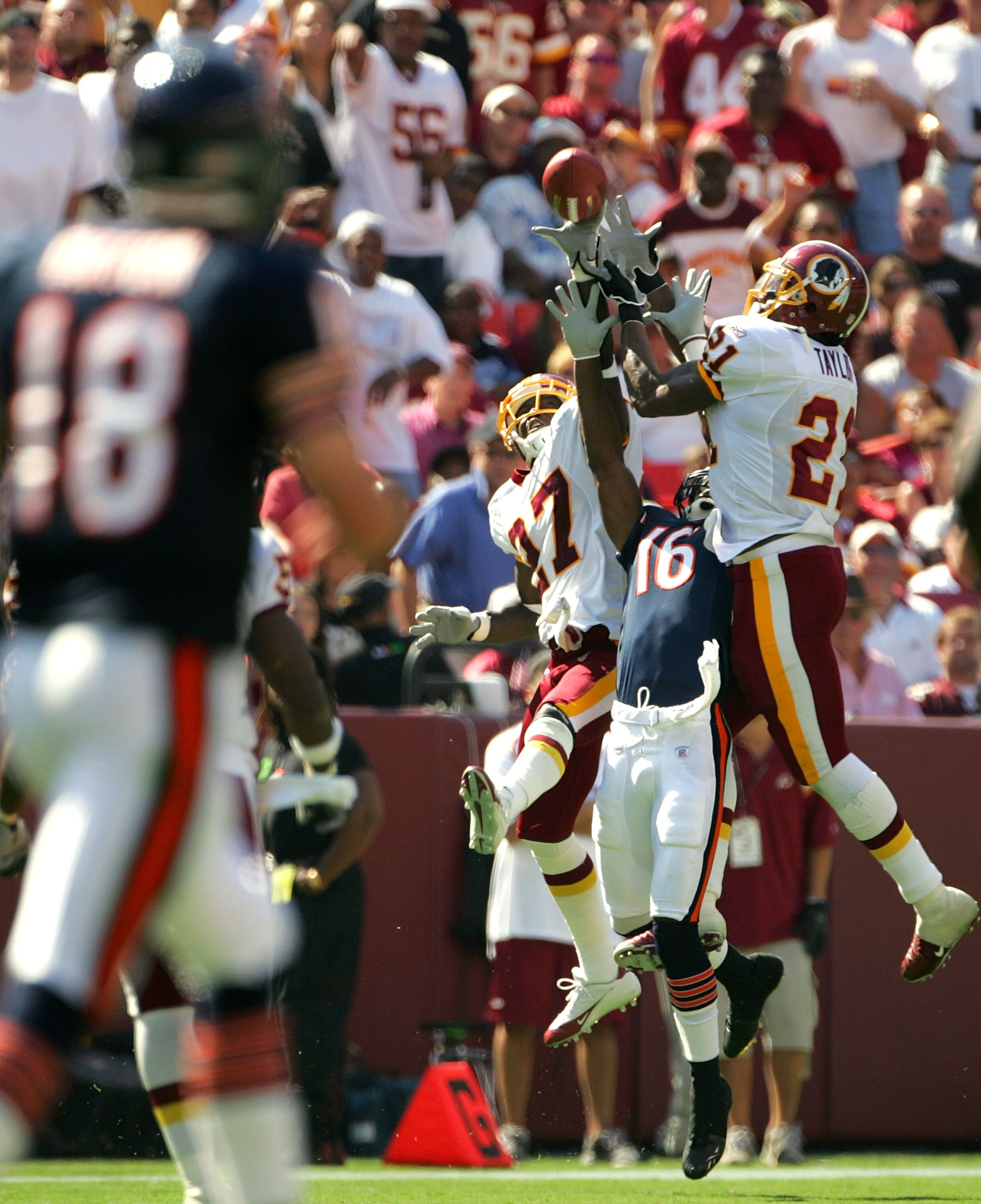 LANDOVER, MD - SEPTEMBER 11:  Quarterback Kyle Orton #18 of the Chicago Bears looks on as Sean Taylor #21 and Walt Harris #27 of the Washington Redskins break up a pass intended for Mark Bradley #16 during the second half of the game on September 11, 2005