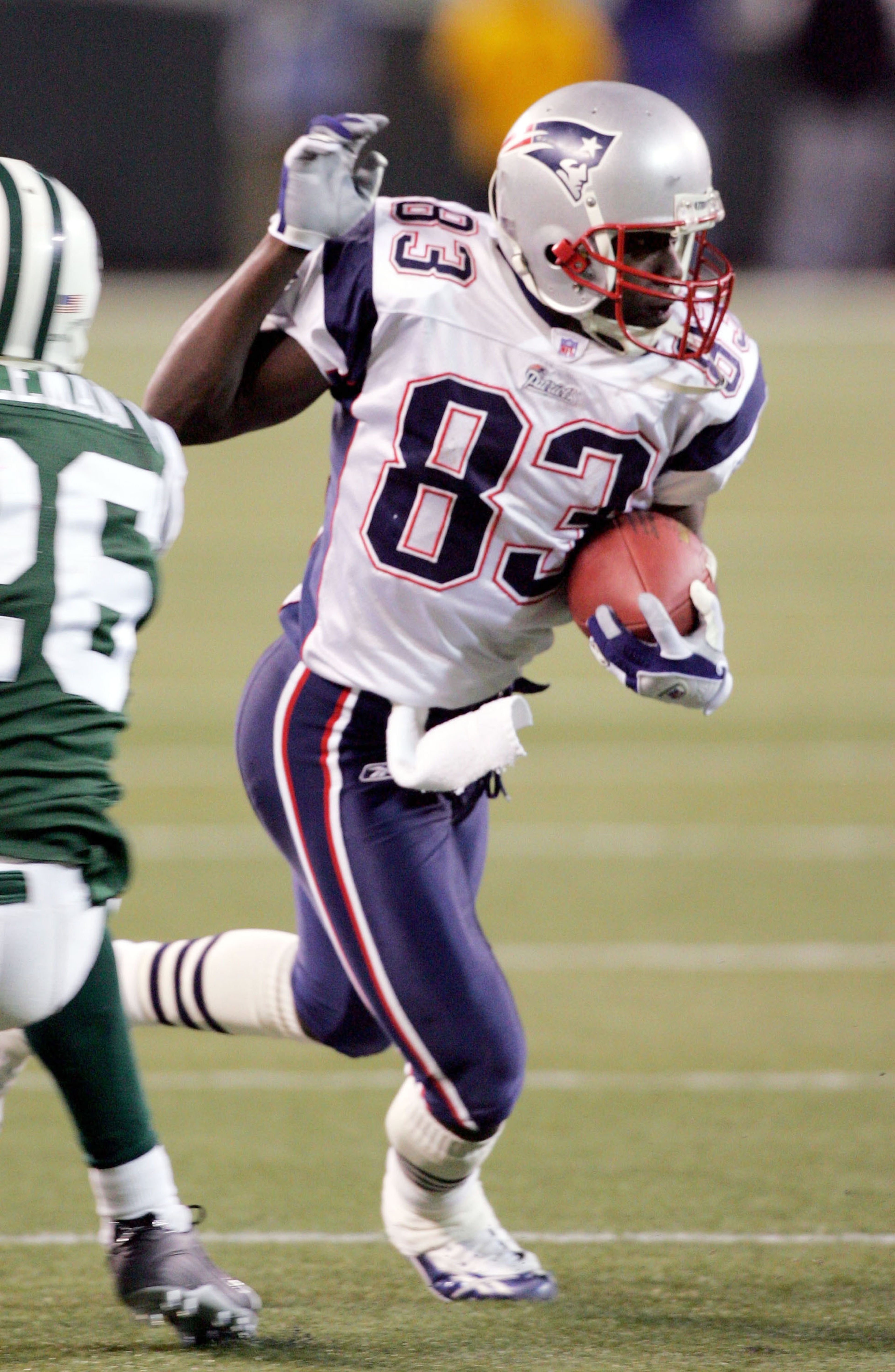 EAST RUTHERFORD, NJ - DECEMBER 26:  Deion Branch #83 of the New England Patriots runs the ball past Erik Coleman #26 of the New York Jets after a reception during the game on December 26, 2005 at Giants Stadium in East Rutherford, New Jersey. The Patriots