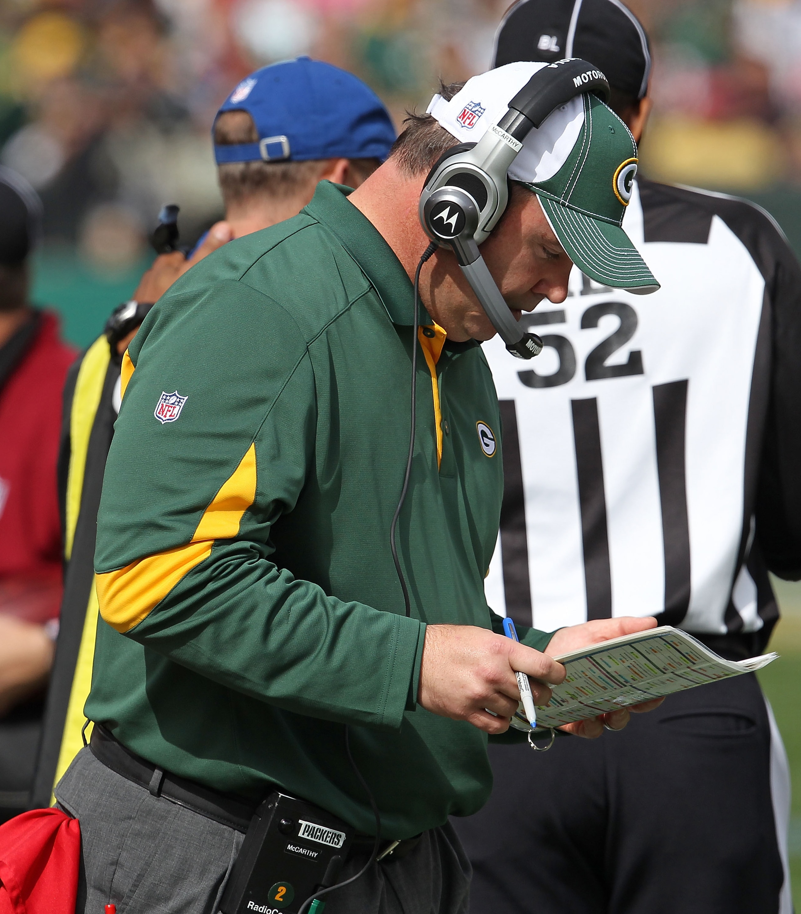 GREEN BAY, WI - SEPTEMBER 19: Head coach Mike McCarthy of the Green Bay Packers checks his play list as his team takes on the Buffalo Bills at Lambeau Field on September 19, 2010 in Green Bay, Wisconsin. The Packers defeated the Bills 34-7.  (Photo by Jon