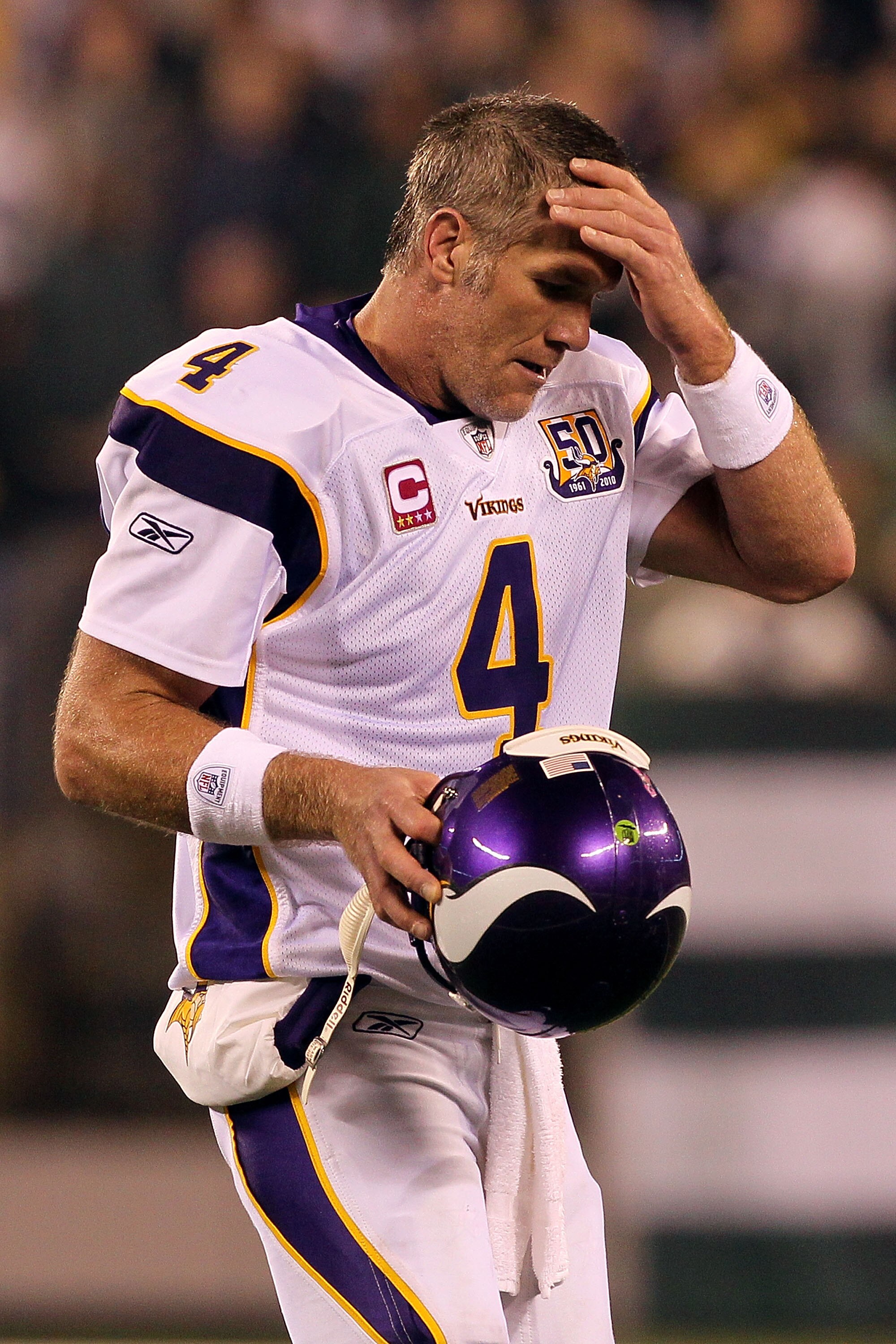 EAST RUTHERFORD, NJ - OCTOBER 11:  Quarterback Brett Favre #4 of the Minnesota Vikings wipes his forehead as he walks on the field in the second half against the New York Jets at New Meadowlands Stadium on October 11, 2010 in East Rutherford, New Jersey.