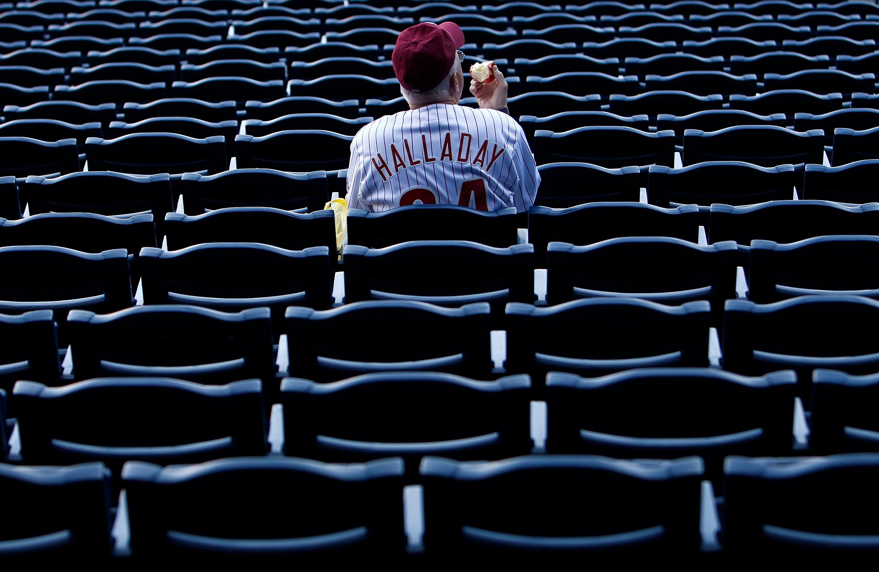 PHILADELPHIA - OCTOBER 08:  A fan wearing a Roy Halladay #34 of the Philadelphia Phillies jersey watches batting practice before Game 2 of the NLDS against the Cincinnati Reds at Citizens Bank Park on October 8, 2010 in Philadelphia, Pennsylvania.  (Photo