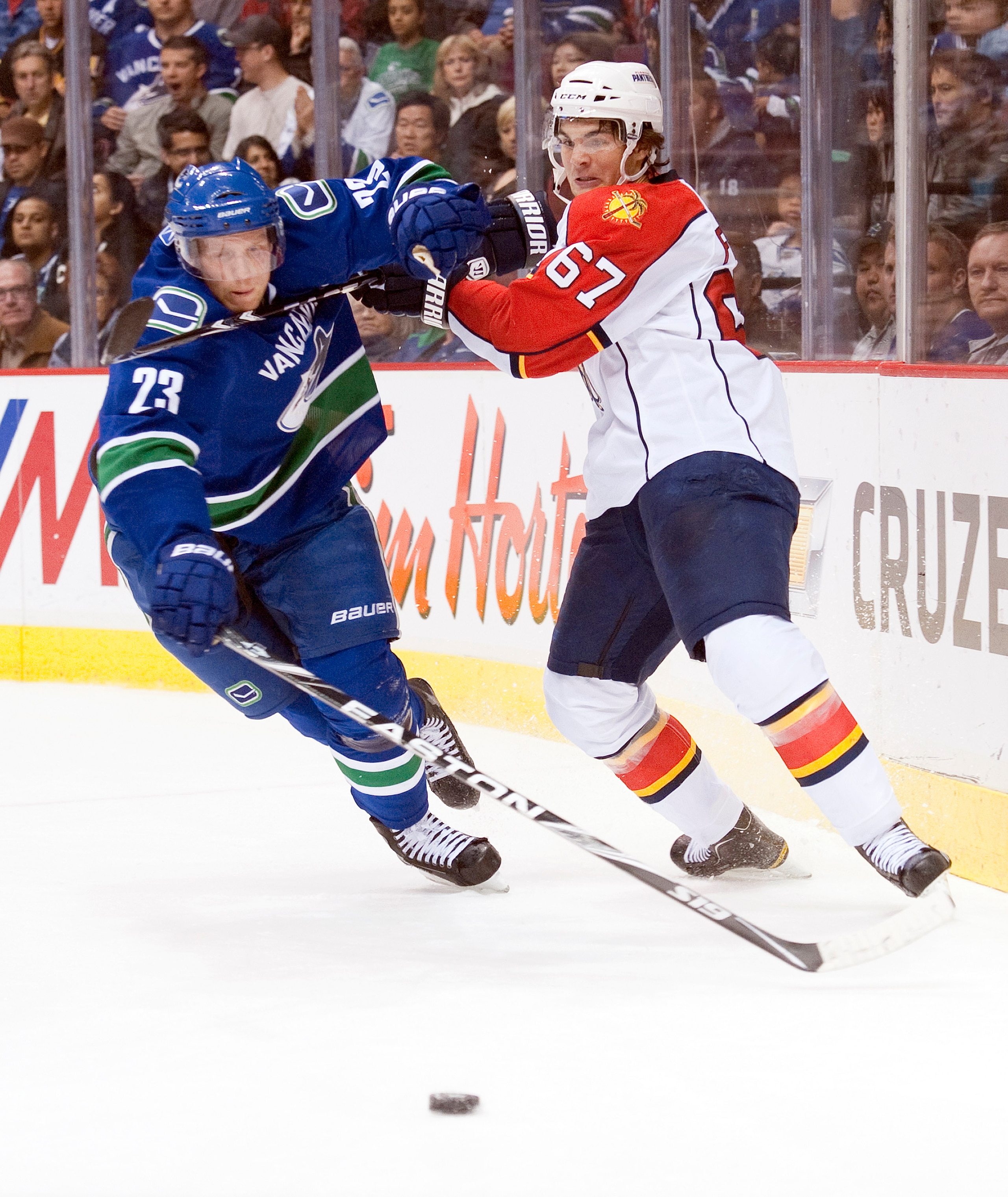 VANCOUVER, CANADA - OCTOBER 11: Michael Frolik #67 of the Florida Panthers tries to tie up Alexander Edler #23 of the Vancouver Canucks while chasing down a loose puck during the first period in NHL action on October 11, 2010 at Rogers Arena in Vancouver,