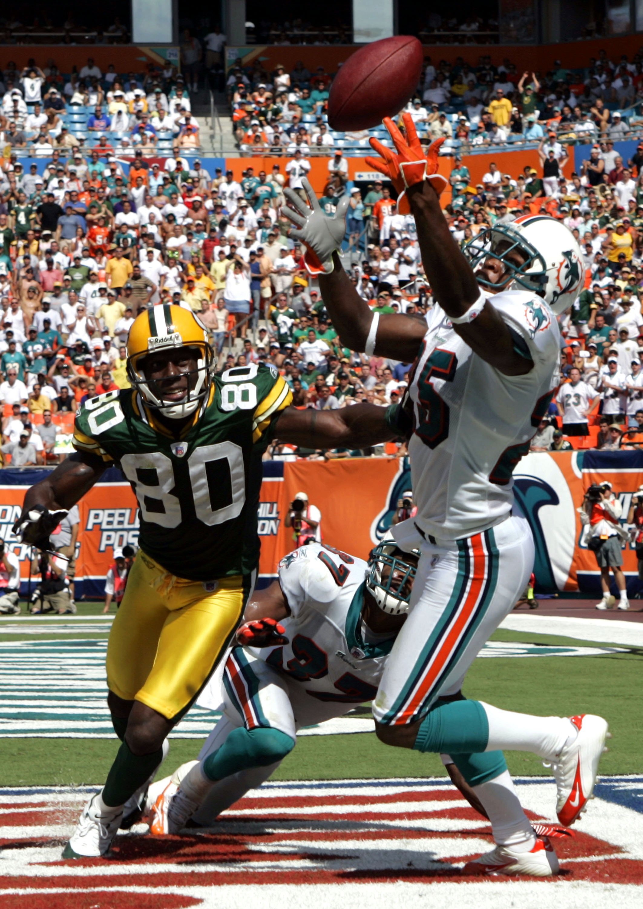 MIAMI - OCTOBER 22:  Corner back Will Allen #25 of the Miami Dolphins tries to catch the ball in the endzone against wide receiver Donald Driver #80 of the Green Bay Packers at Dolphin Stadium on October 22, 2006 in Miami, Florida. (Photo by Eliot J. Sche