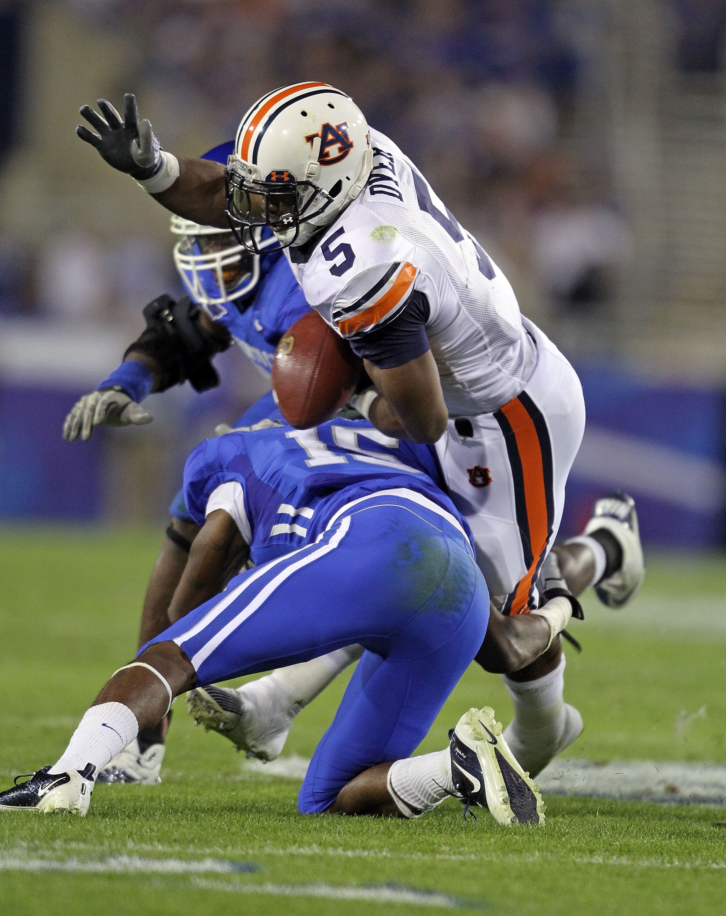 LEXINGTON, KY - OCTOBER 09:  Michael Dyer #5 of the Auburn Tigers fumbles the ball while tackled by Martavius Neloms #15 of the Kentucky Wildcats during the SEC game at Commonwealth Stadium on October 9, 2010 in Lexington, Kentucky.  (Photo by Andy Lyons/
