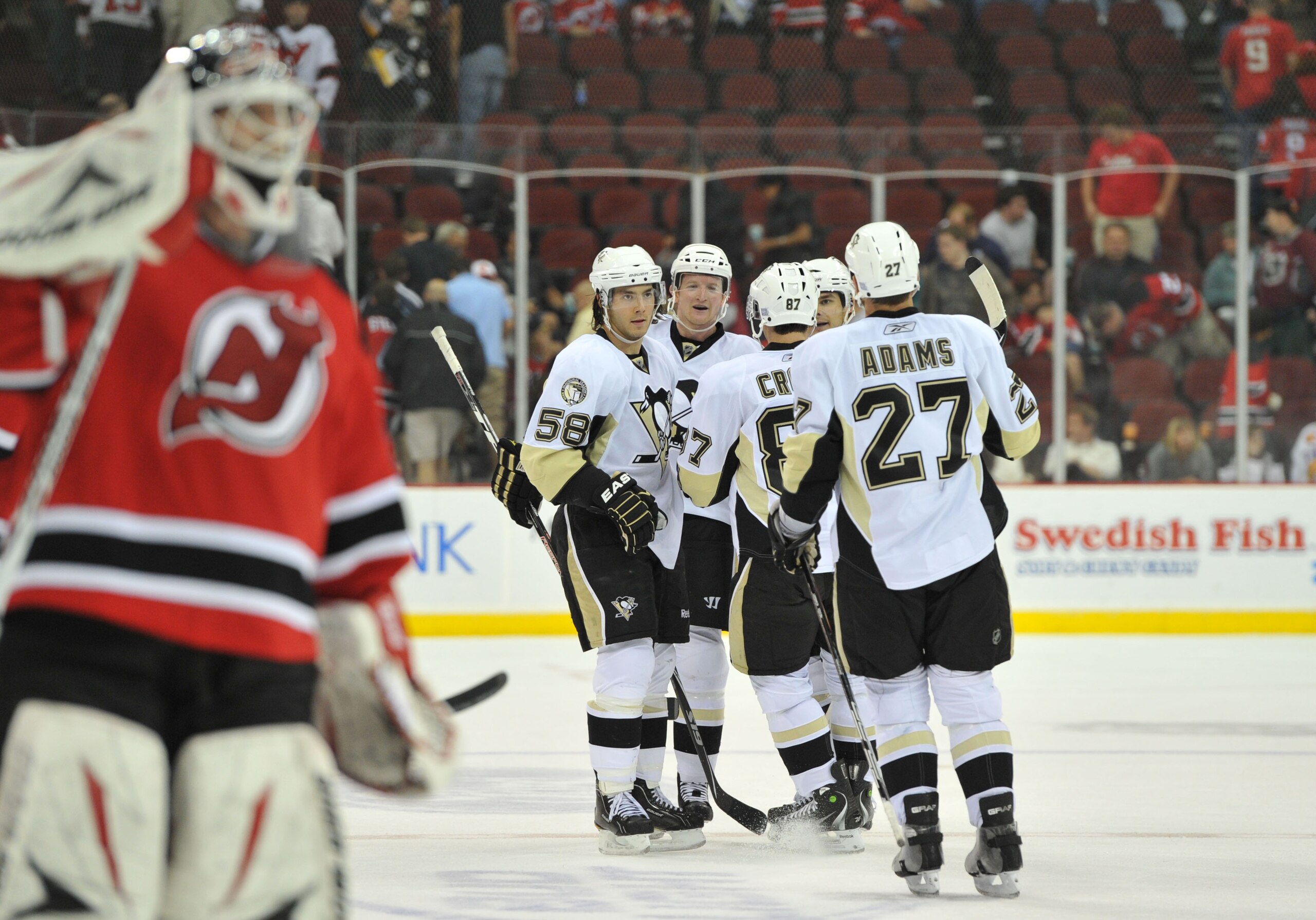 NEWARK, NJ - OCTOBER 11: Martin Brodeur #30 of the New Jersey Devils (Center-L) skates back to his position as Paul Martin #7 of the Pittsburgh Penguins (third from left) is congratulated after scoring an empty net goal in the third period at the Prudenti