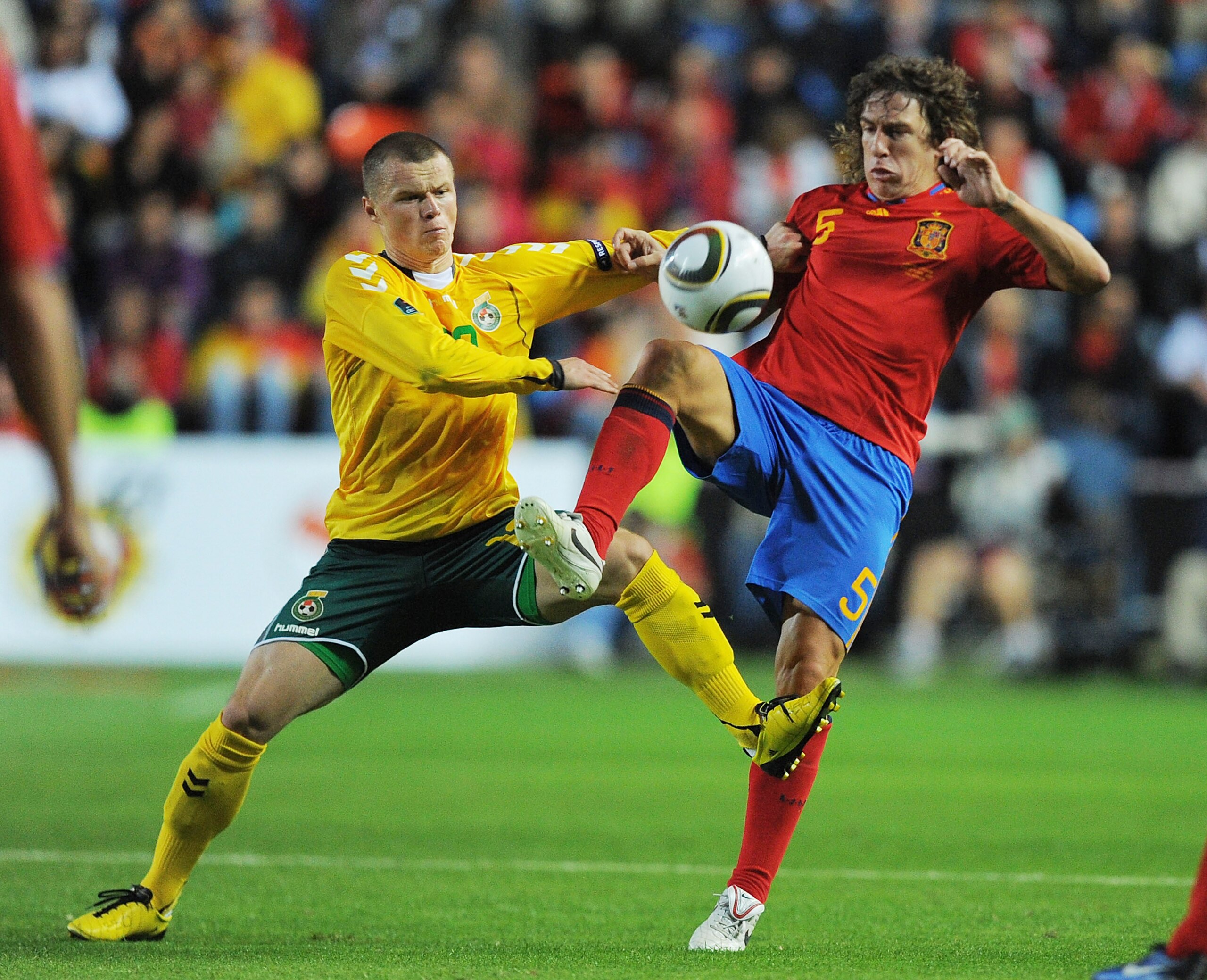 SALAMANCA, SPAIN - OCTOBER 08: Carles Puyol (R) of Spain clashes with Darvydas Sernas of Lithuania during the EURO 2012 Qualifying Group I match between Spain and Lithuania at the Helmantico stadium on October 8, 2010 in Salamanca, Spain.  (Photo by Denis