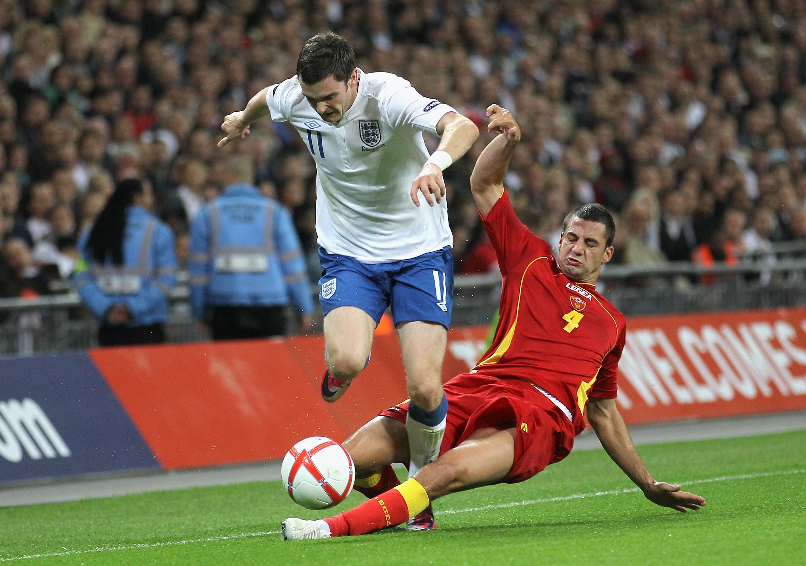 LONDON, ENGLAND - OCTOBER 12: Adam Johnson of England is tackled by Milan Jovanovic of Montenegro during the UEFA EURO 2012 Group G Qualifying match between England and Montenegro at Wembley Stadium on October 12, 2010 in London, England.  (Photo by Hamis