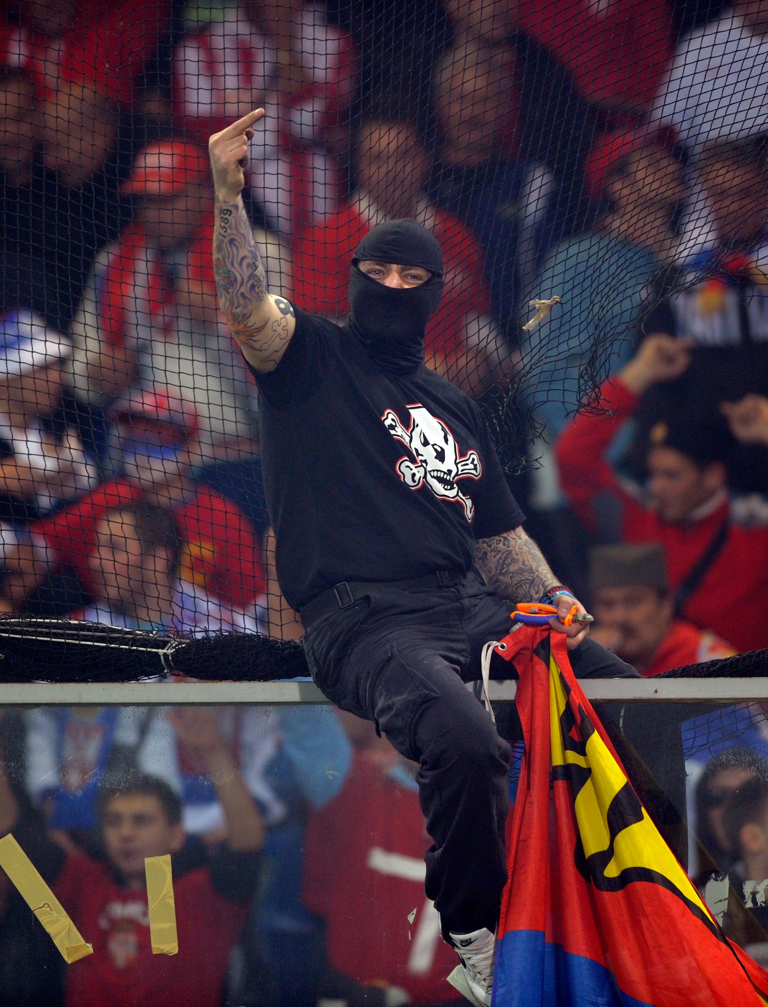 GENOA, ITALY - OCTOBER 12: Balaclava clad Serbian fan Ivan Bogdanov gestures towards riot police during the UEFA EURO 2012 Group C qualifier between Italy and Serbia at Luigi Ferraris Stadium on October 12, 2010 in Genoa, Italy. (Photo by Claudio Villa/Ge
