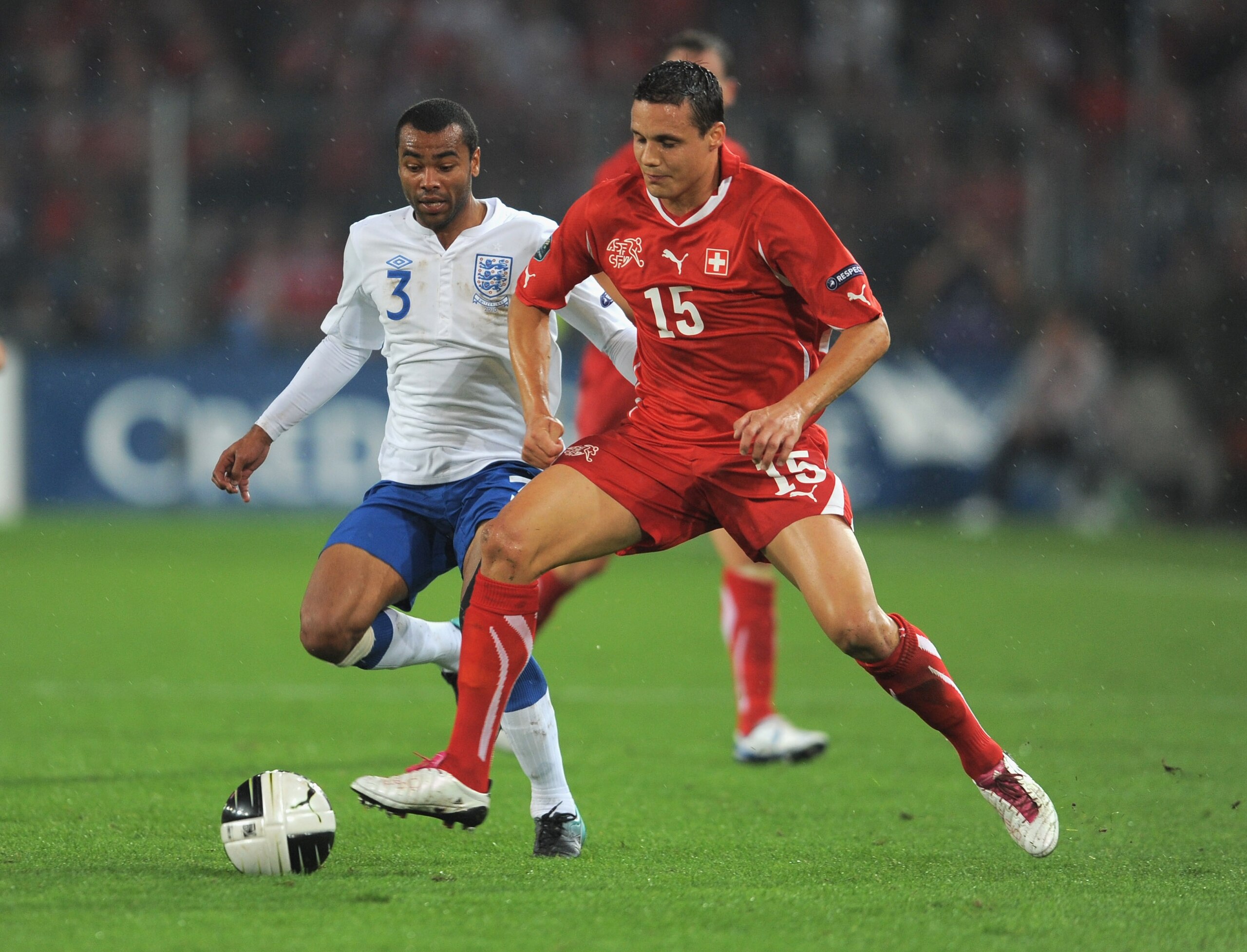 BASEL, SWITZERLAND - SEPTEMBER 07: David Degan of Switzerland in action with Ashley Cole of England during the EURO 2012 Group G Qualifier between Switzerland and England at St Jakob Park on September 7, 2010 in Basel, Switzerland.  (Photo by Michael Rega