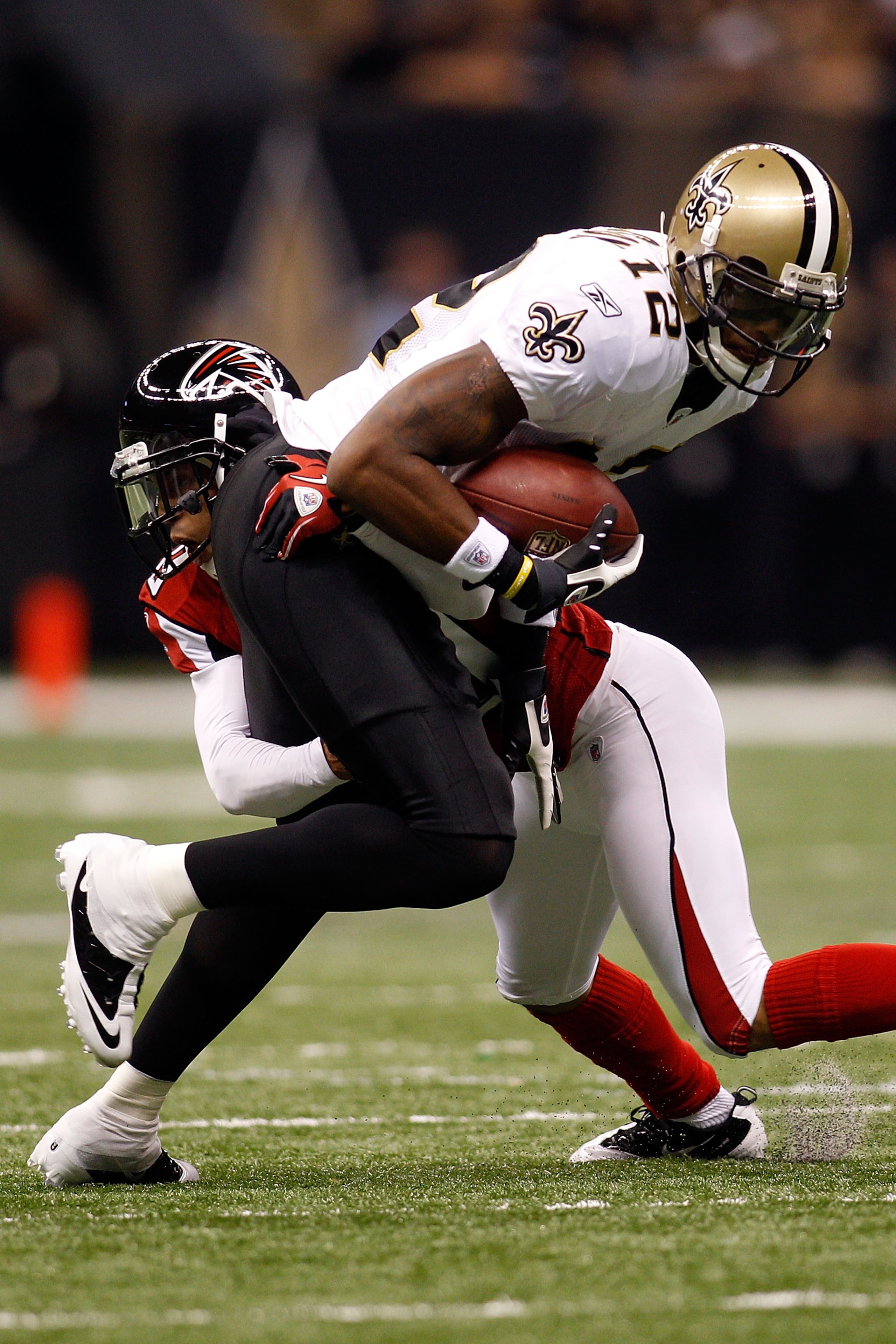 NEW ORLEANS - SEPTEMBER 26:  Marques Colston #12 of the New Orleans Saints is tackled by Brent Grimes #20 of the Atlanta Falcons at the Louisiana Superdome on September 26, 2010 in New Orleans, Louisiana.  The Falcons defeated the Saints 27-24.  (Photo by