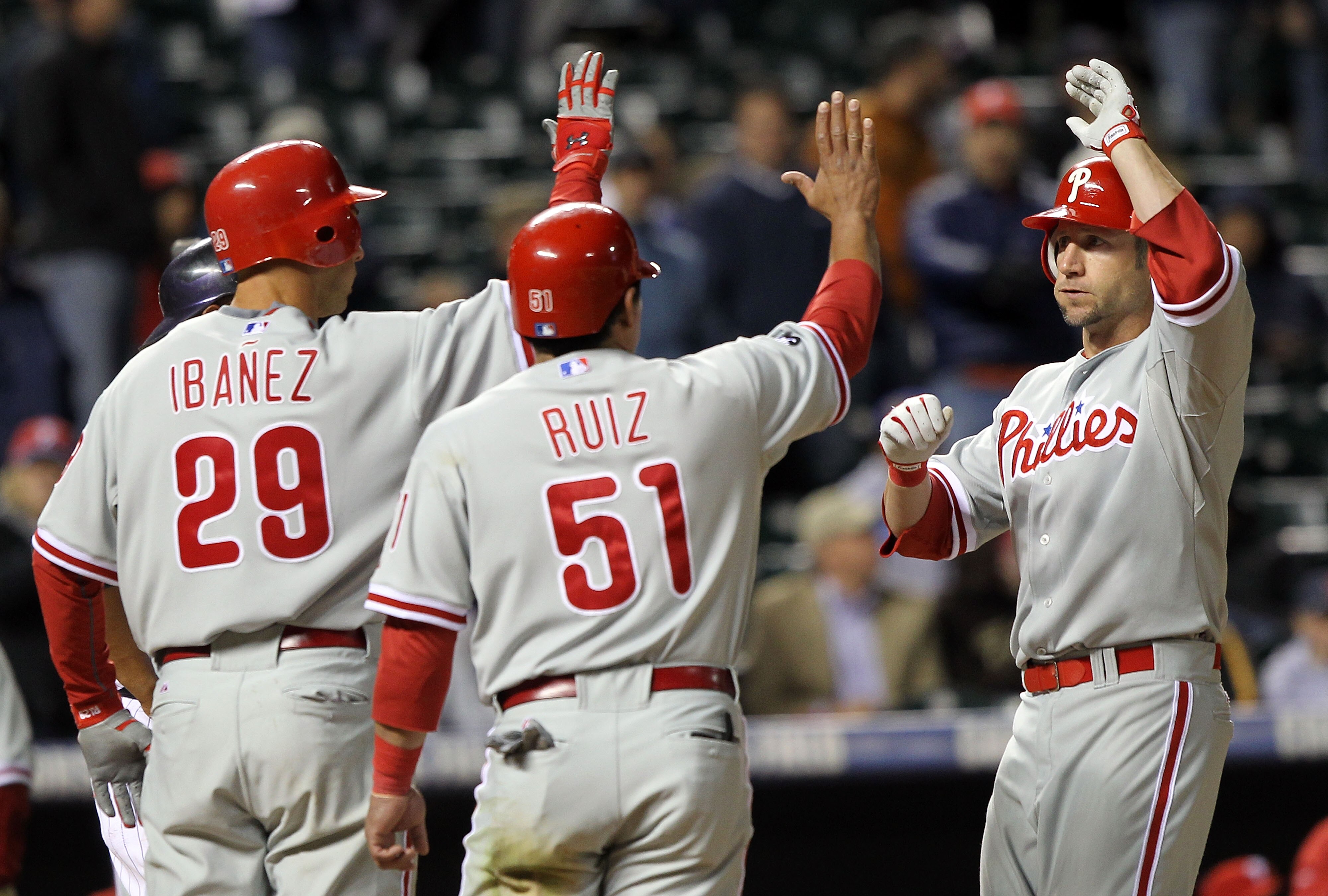 DENVER - MAY 10:  Ross Gload #3 of the Philadelphia Phillies is welcomed home by Carlos Ruiz #51 and Raul Ibanez #29 who scored on his three run pinch hit homerun off of Manuel Corpas #60 of the Colorado Rockies in the ninth inning at Coors Field on May 1