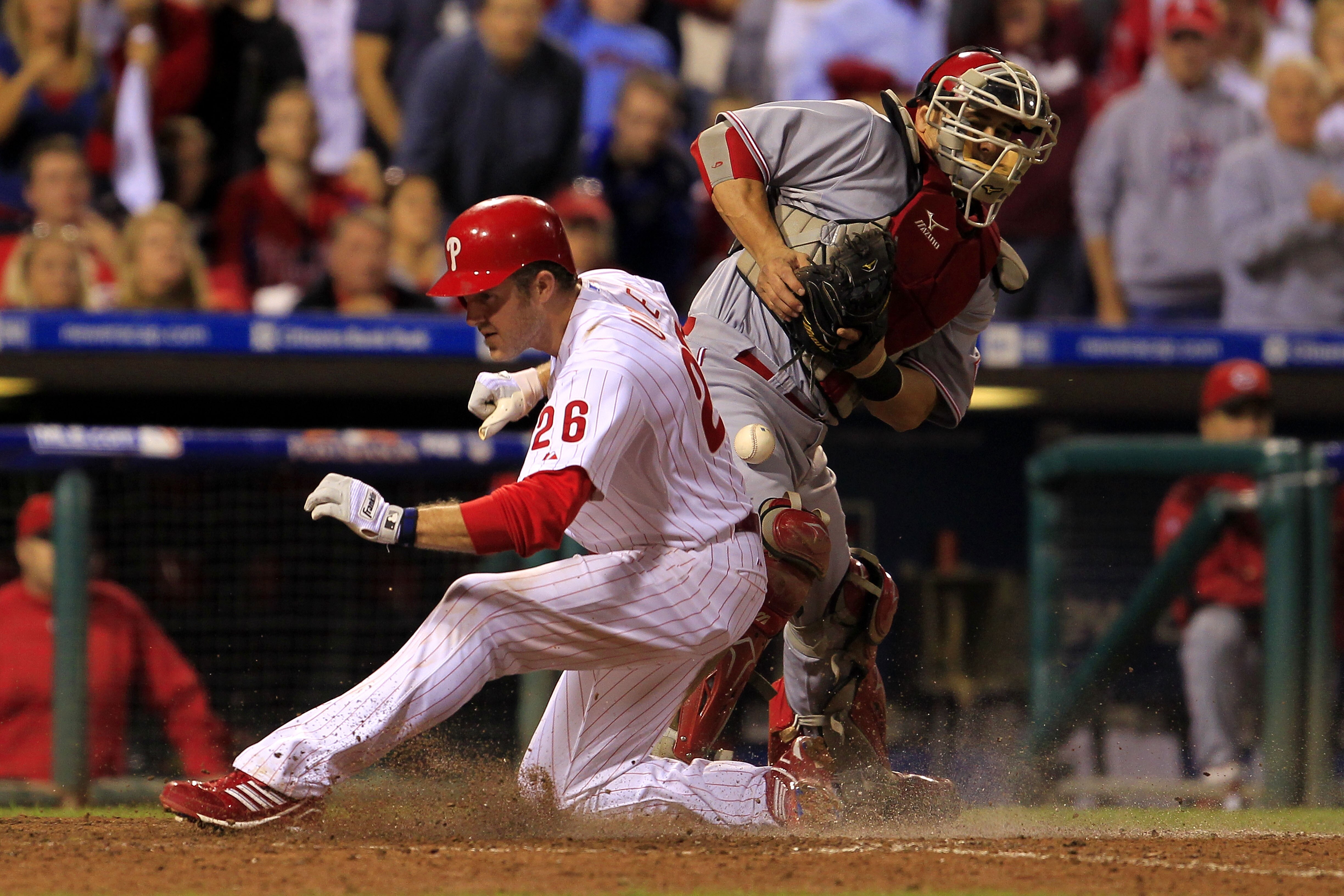 PHILADELPHIA - OCTOBER 08: Chase Utley #28 of the Philadelphia Phillies crosses the plate to score in front of Ryan Hanigan #29 of the Cincinnati Reds in game 2 of NLDS at Citizens Bank Park on October 8, 2010 in Philadelphia, Pennsylvania. The Phillies d