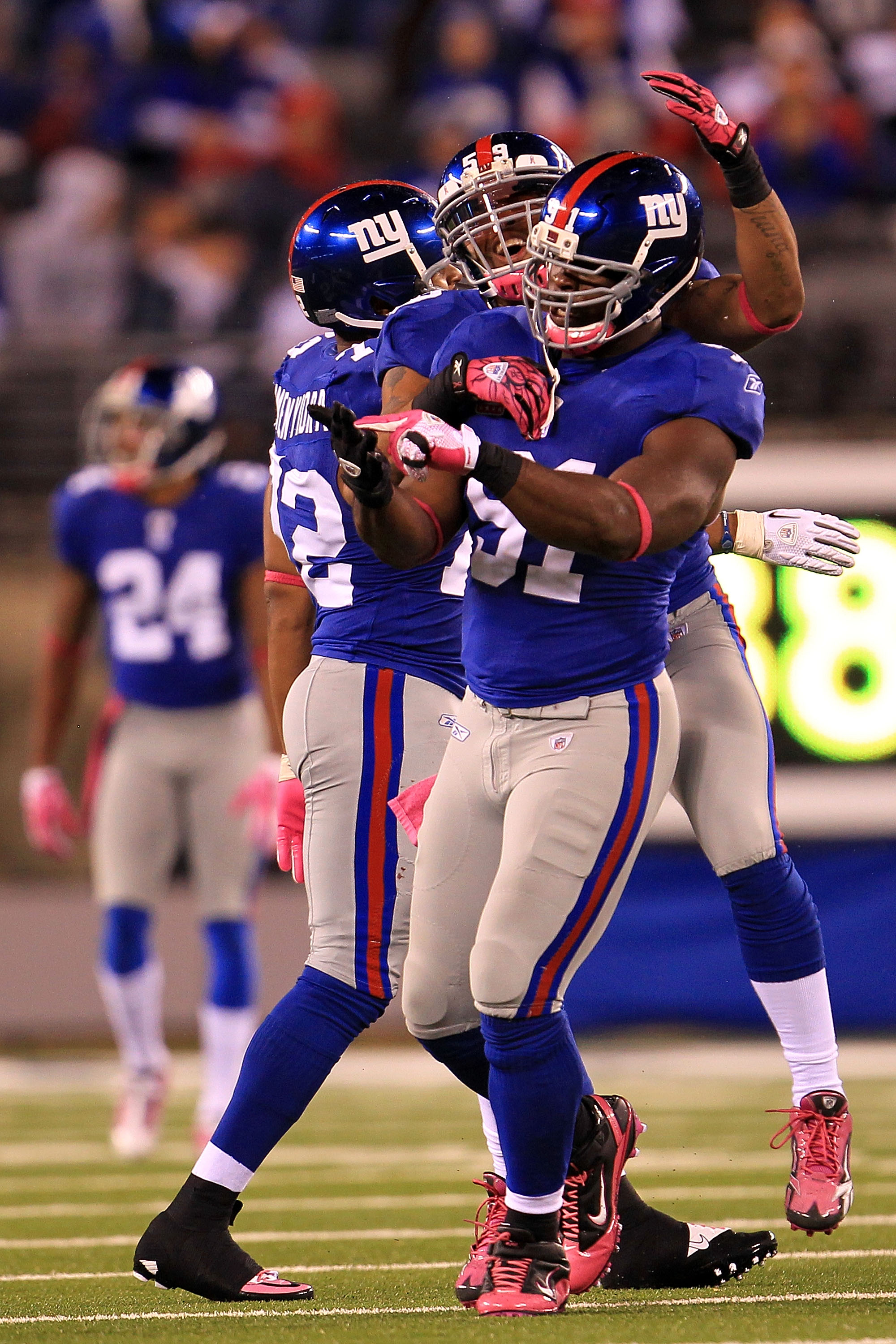 EAST RUTHERFORD, NJ - OCTOBER 03:  Osi Umenyiora #72, Justin Tuck #91 and Michael Boley #59 of the New York Giants celebrate after a sack against the Chicago Bear at New Meadowlands Stadium on October 3, 2010 in East Rutherford, New Jersey.  (Photo by Chr