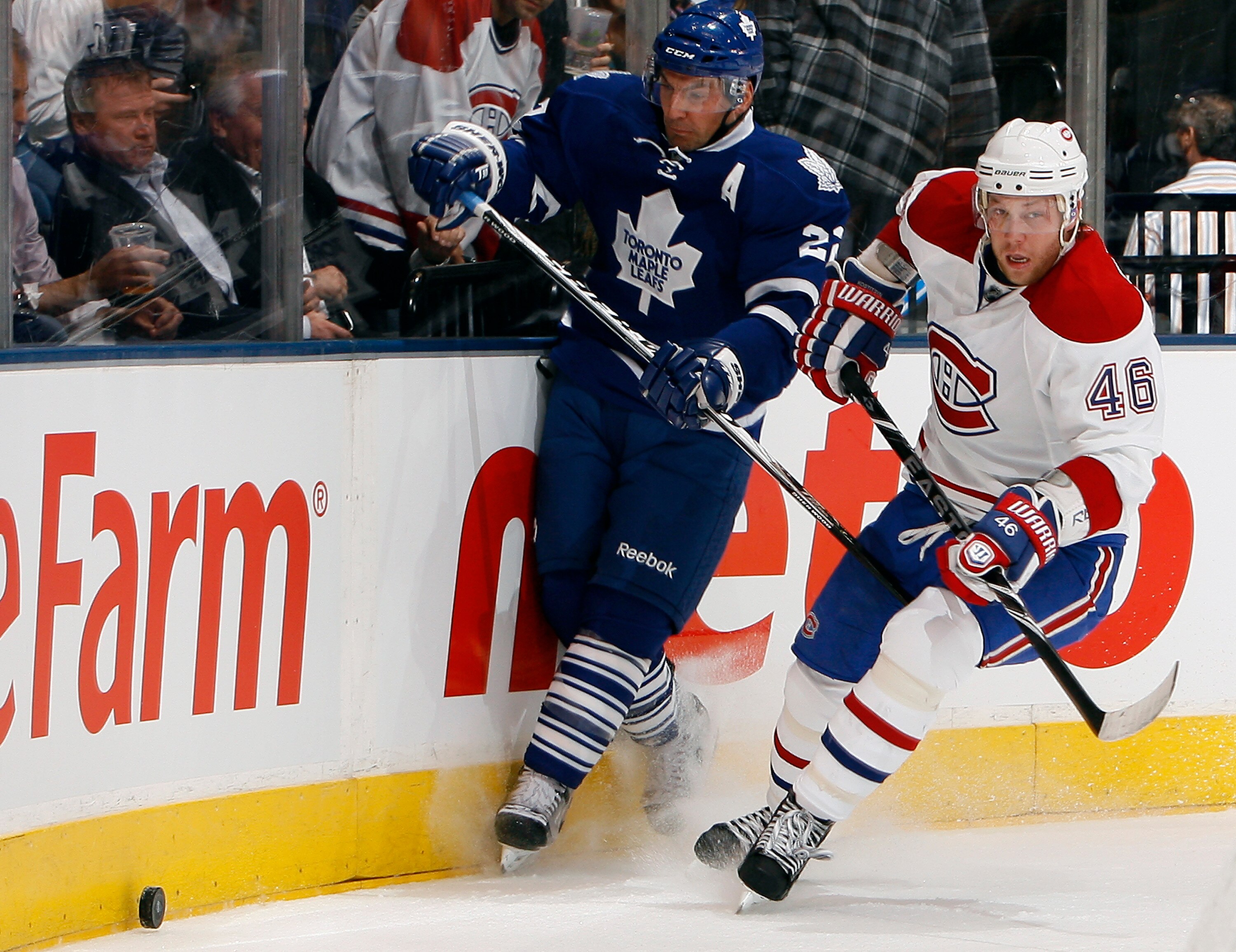 TORONTO - OCTOBER 7: Francois Beauchemin #22  of the Toronto Maple Leafs gets bumped by Andrei Kostitsyn #46 of the Montreal Canadiens during a regular season NHL game against the Toronto Maple Leafs at the Air Canada Centre October 7, 2010 in Toronto, On