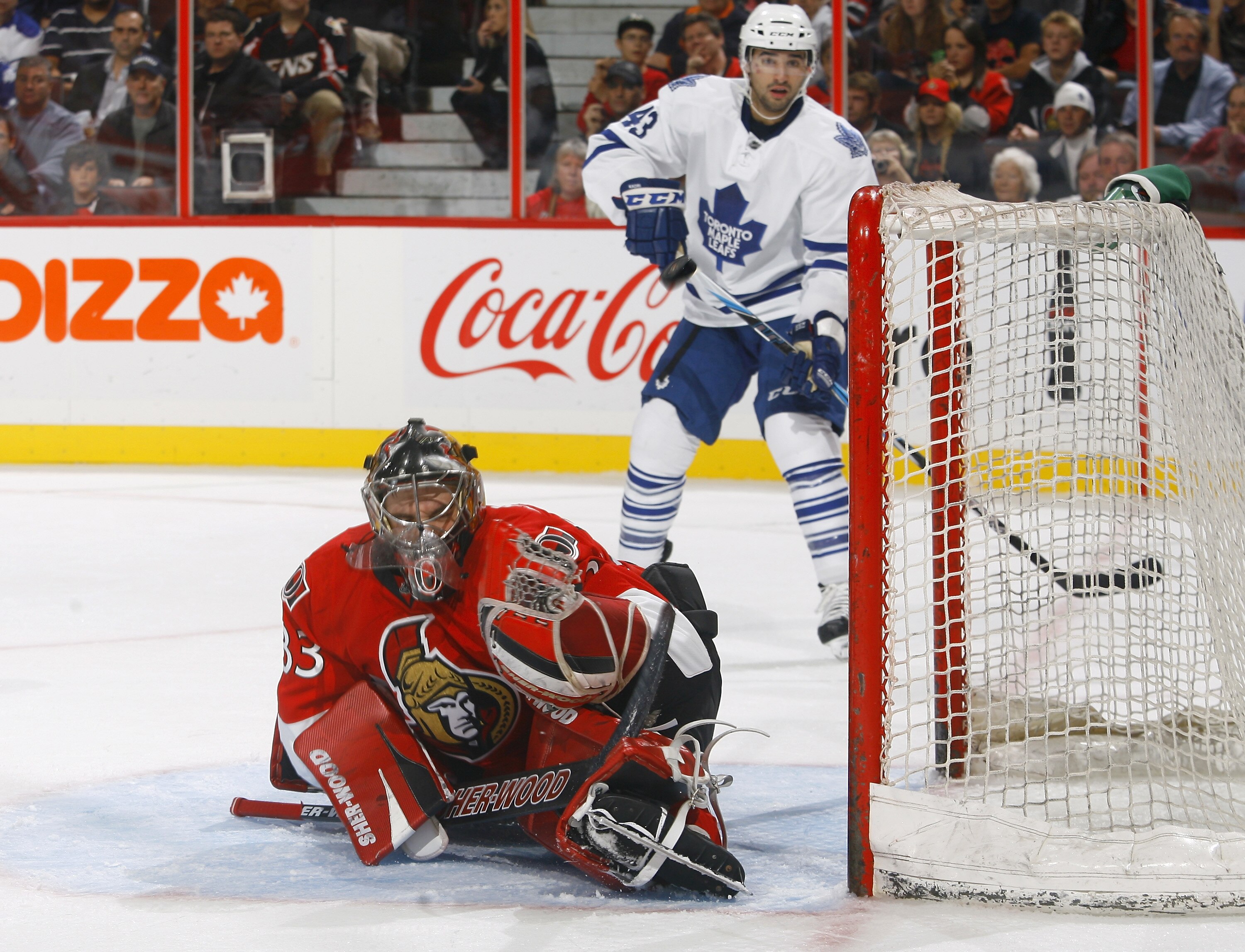 KANATA, ON - SEPTEMBER 29:   Pascal Leclaire #33 of the Ottawa Senators makes a huge glove save off a point blank shot while Nazem Kadri #43 of the Toronto Maple Leafs looks on from the far side of the net at Scotiabank Place on September 29, 2010 in Kana