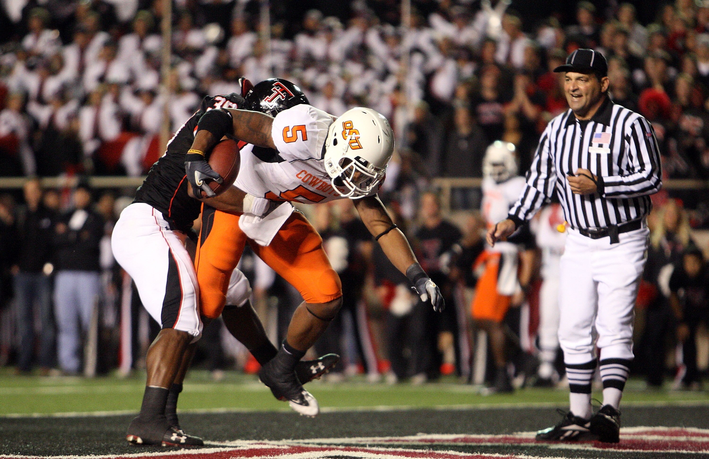 LUBBOCK, TX - NOVEMBER 08:  Running back Keith Toston #5 of the Oklahoma State Cowboys scores a touchdown against Marlon Williams #39 of the Texas Tech Red Raiders at Jones AT&T Stadium on November 8, 2008 in Lubbock, Texas.  (Photo by Ronald Martinez/Get