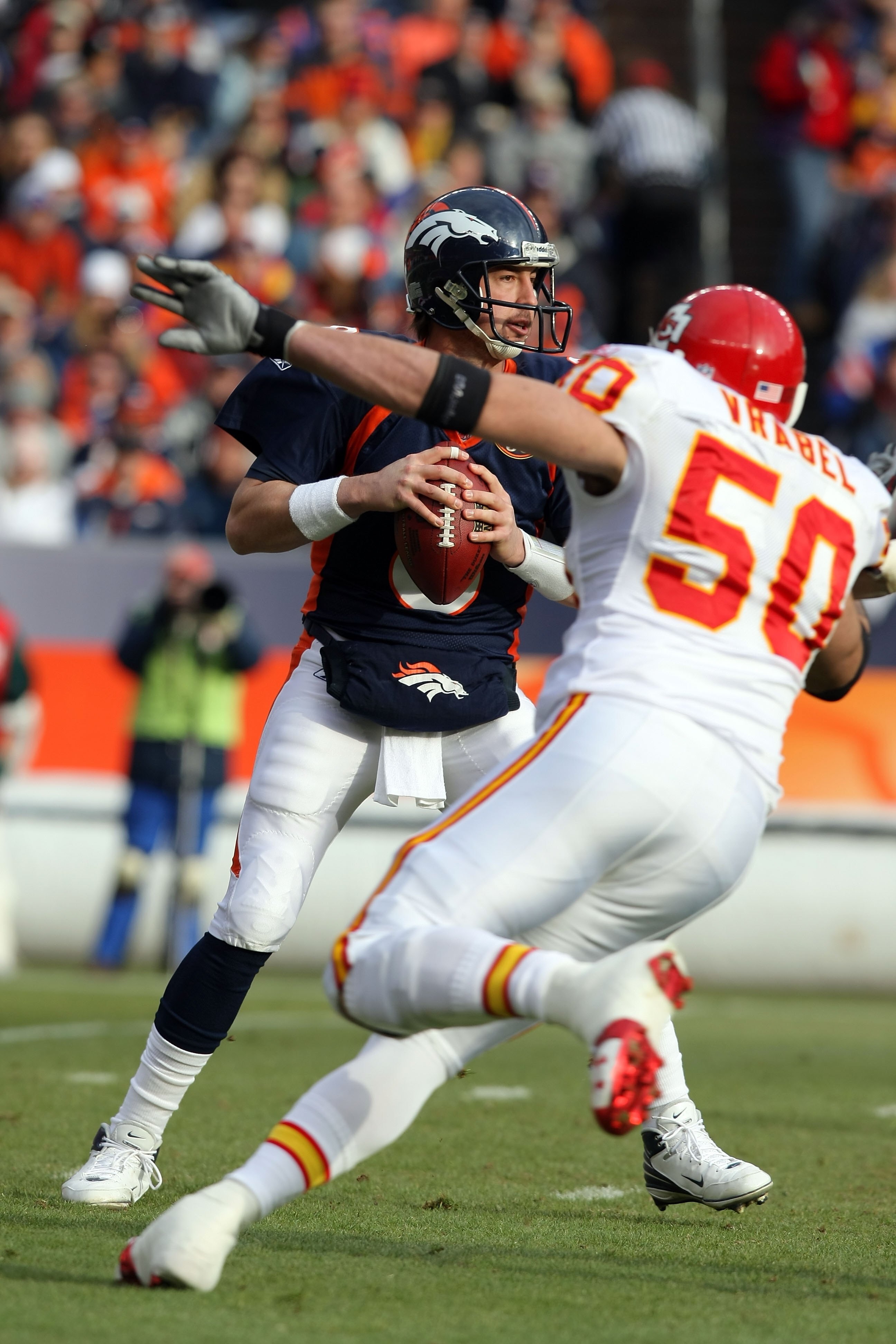 DENVER - JANUARY 03:  Quarterback Kyle Orton #8 of the Denver Broncos drops back to pass while under pressure from line backer Mike Vrabel #50 of the Kansas City Chiefs during NFL action at Invesco Field at Mile High on January 3, 2010 in Denver, Colorado