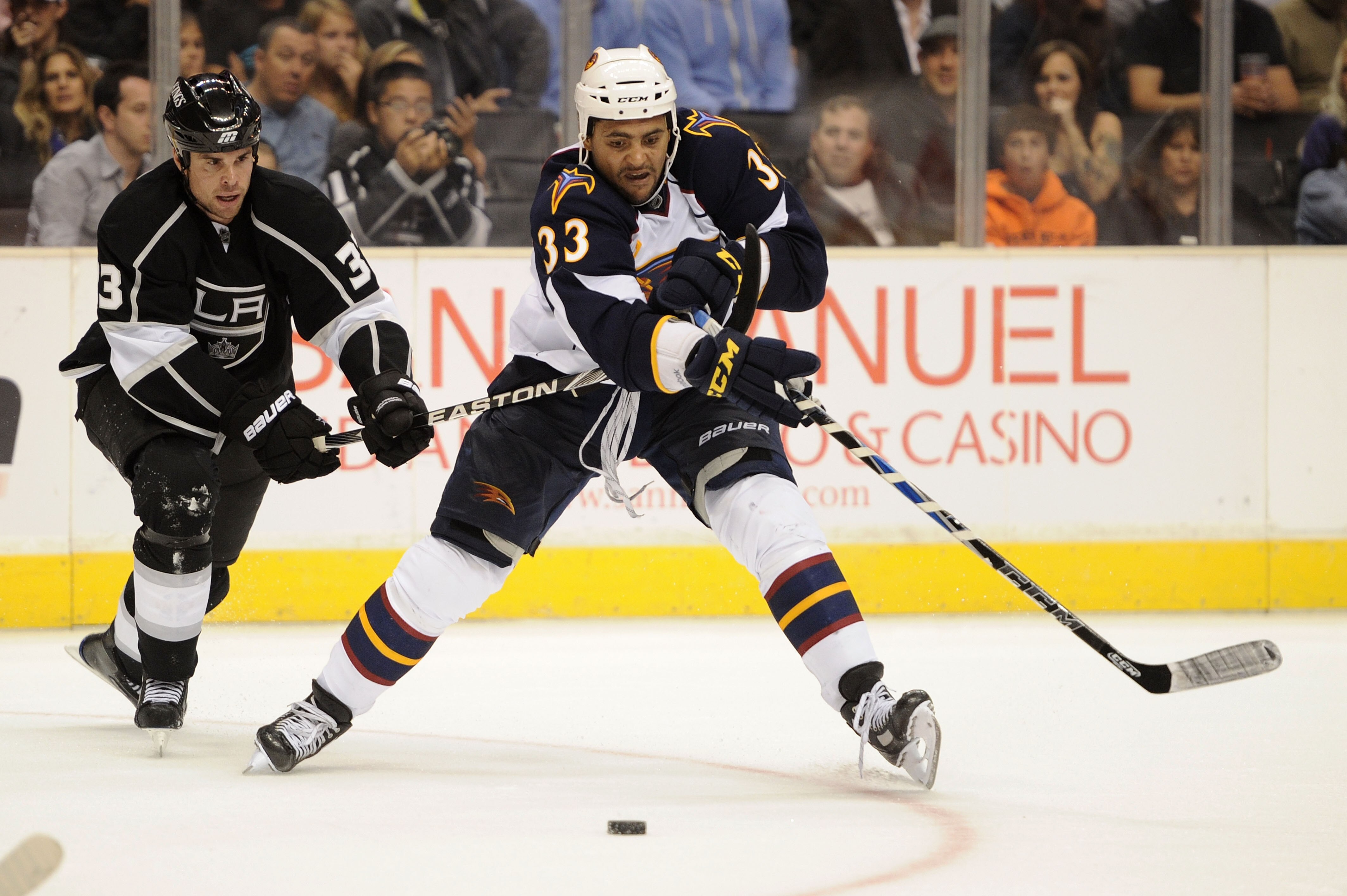 LOS ANGELES, CA - OCTOBER 12:  Dustin Byfuglien #33 of the Atlanta Thrashers fights for control of the puck against Willie Mitchell #33 of the Los Angeles Kings during their game at Staples Center on October 12, 2010 in Los Angeles, California.  (Photo by