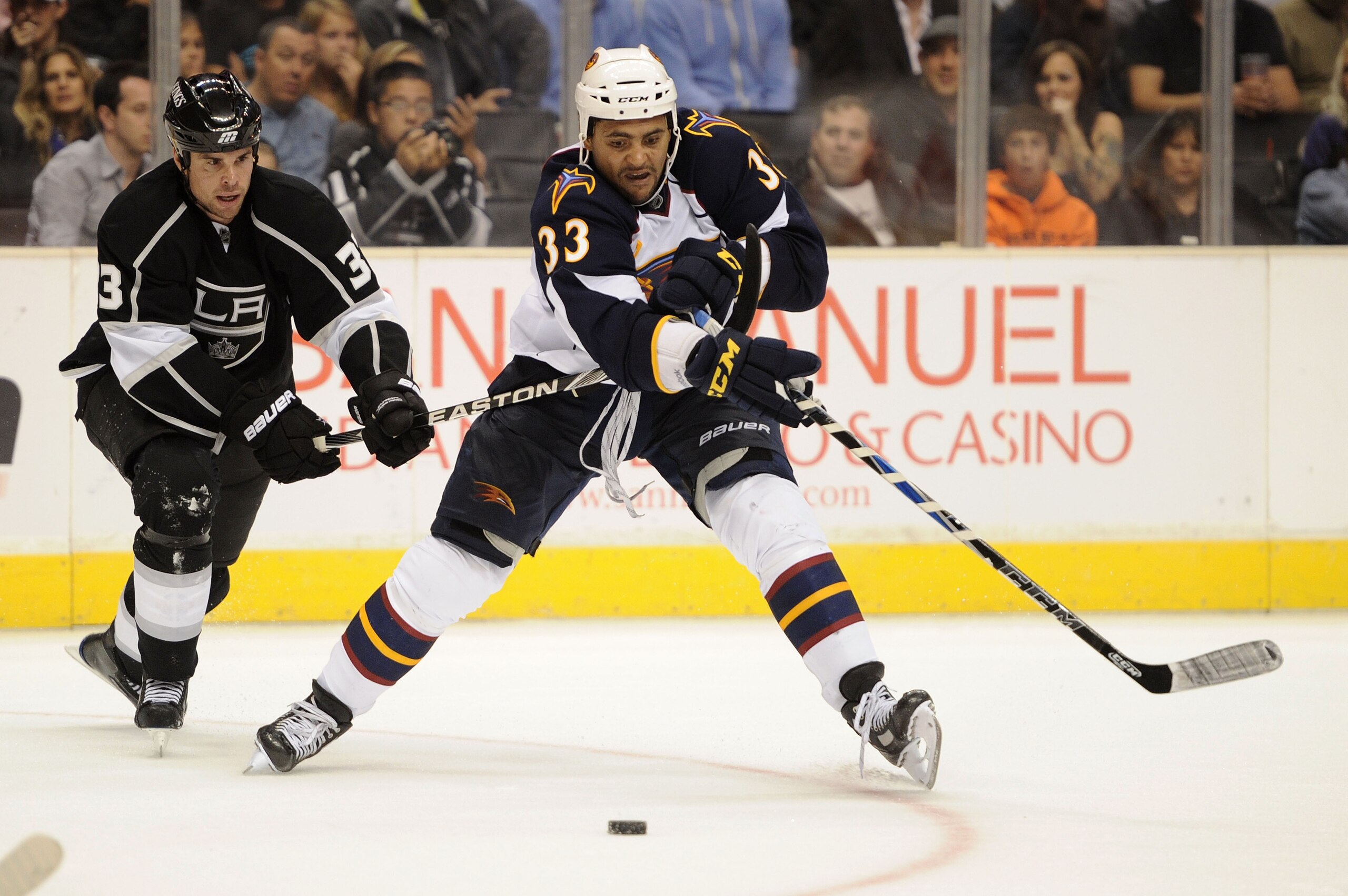 LOS ANGELES, CA - OCTOBER 12:  Dustin Byfuglien #33 of the Atlanta Thrashers fights for control of the puck against Willie Mitchell #33 of the Los Angeles Kings during their game at Staples Center on October 12, 2010 in Los Angeles, California.  (Photo by