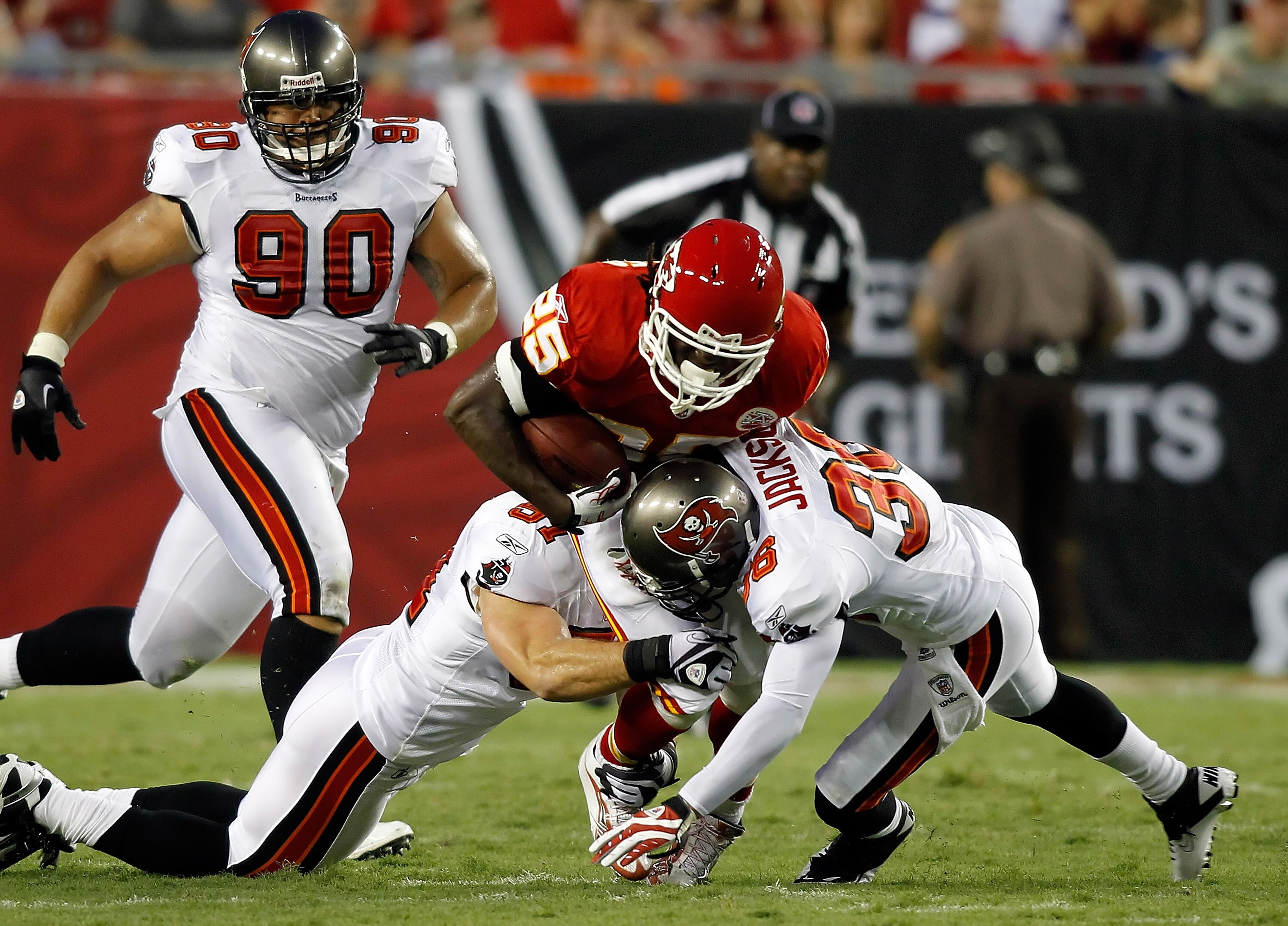 TAMPA, FL - AUGUST 21:  Defenders Barrett Ruud #51 and Tanard Jackson #36 of the Tampa Bay Buccaneers tackle running back Jamaal Charles #25 of the Kansas City Chiefs during a preseason game at Raymond James Stadium on August 21, 2010 in Tampa, Florida.