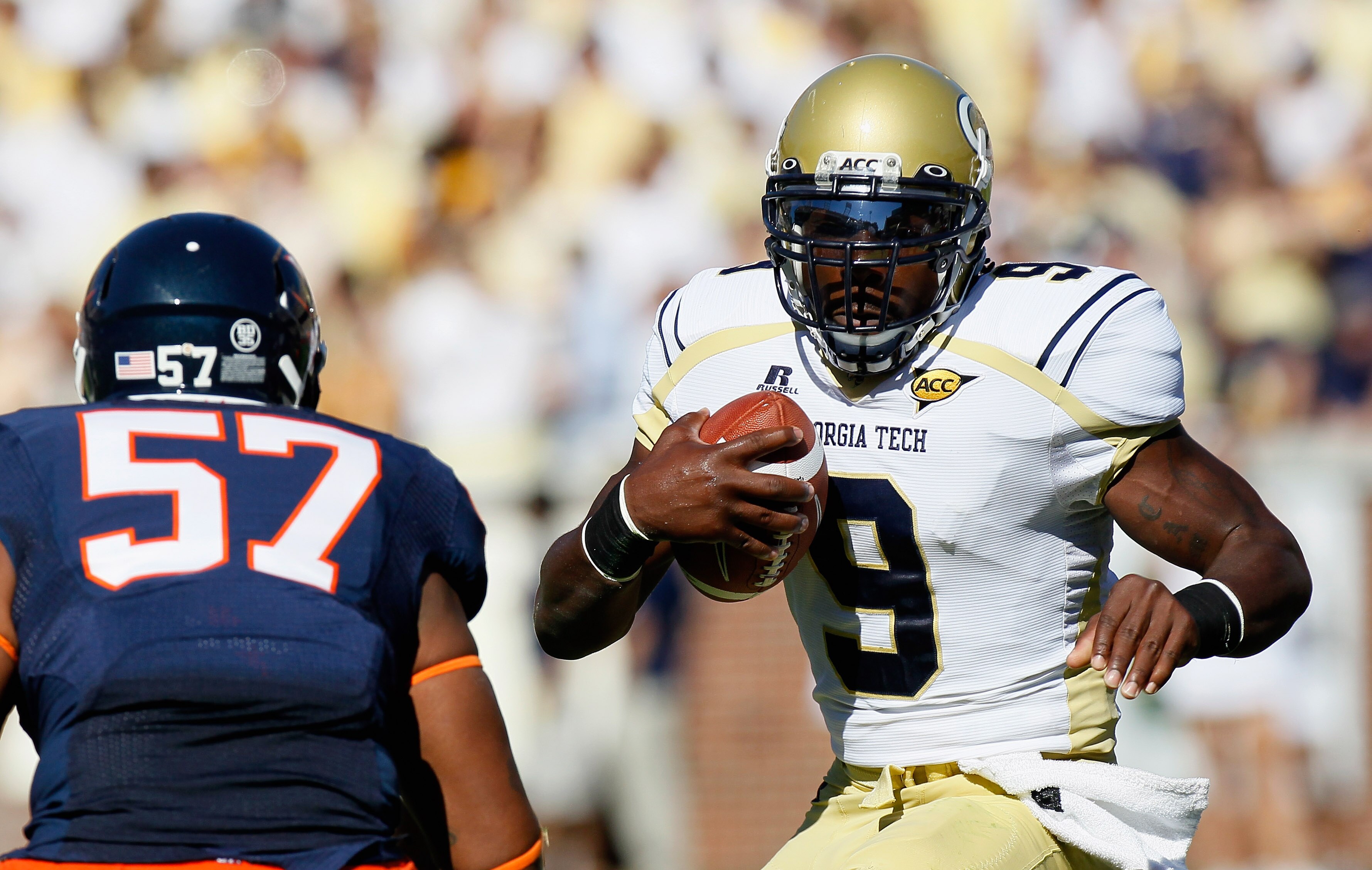 ATLANTA - OCTOBER 09:  Quarterback Joshua Nesbitt #9 of the Georgia Tech Yellow Jackets rushes upfield at Darnell Carter #57 of the Virginia Cavaliers at Bobby Dodd Stadium on October 9, 2010 in Atlanta, Georgia.  (Photo by Kevin C. Cox/Getty Images)