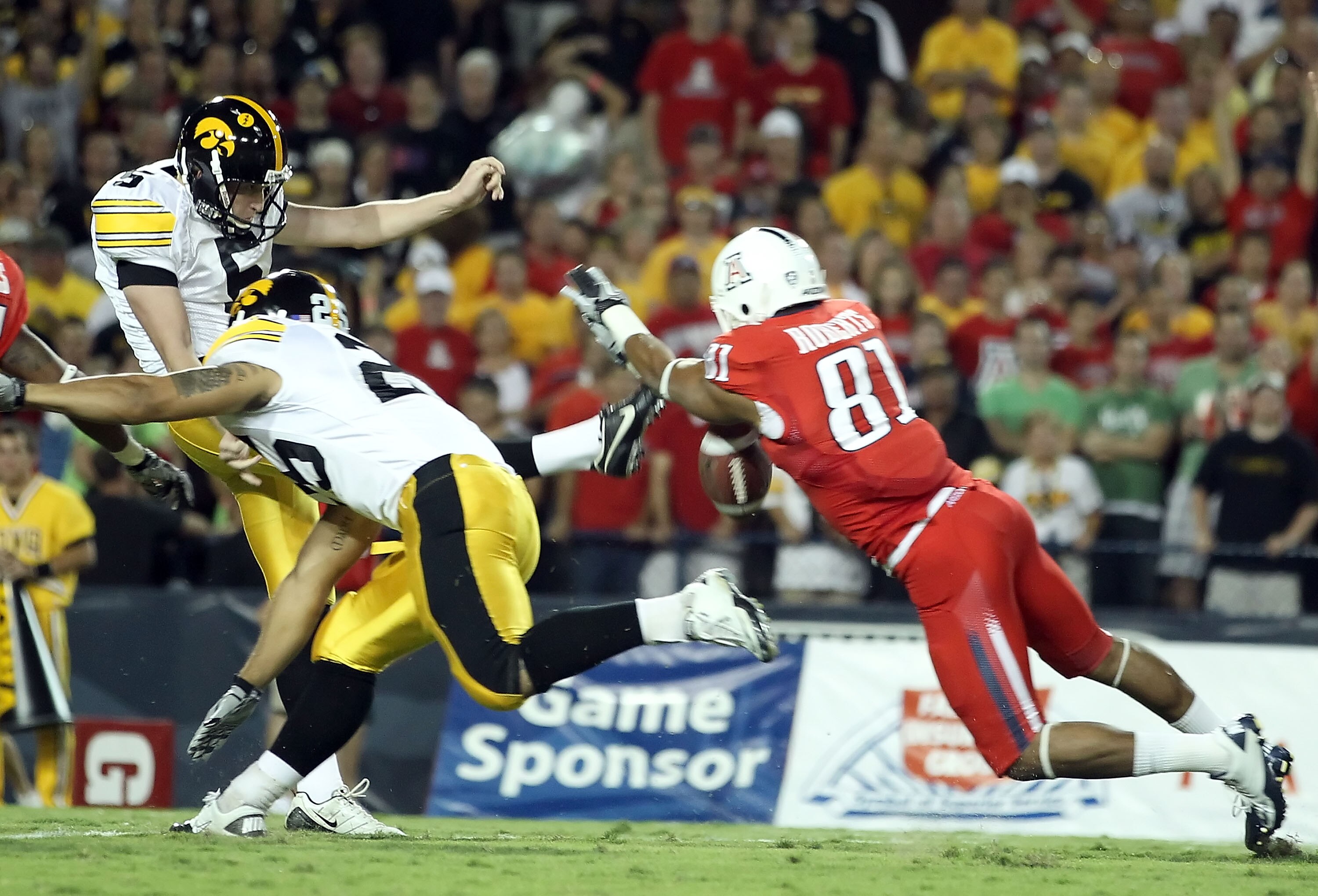 TUCSON, AZ - SEPTEMBER 18:  Punter Ryan Donahue #5 of the Iowa Hawkeyes has a first-quarter punt blocked by the diving David Roberts #81 of the Arizona Wildcats during the college football game at Arizona Stadium on September 18, 2010 in Tucson, Arizona. 