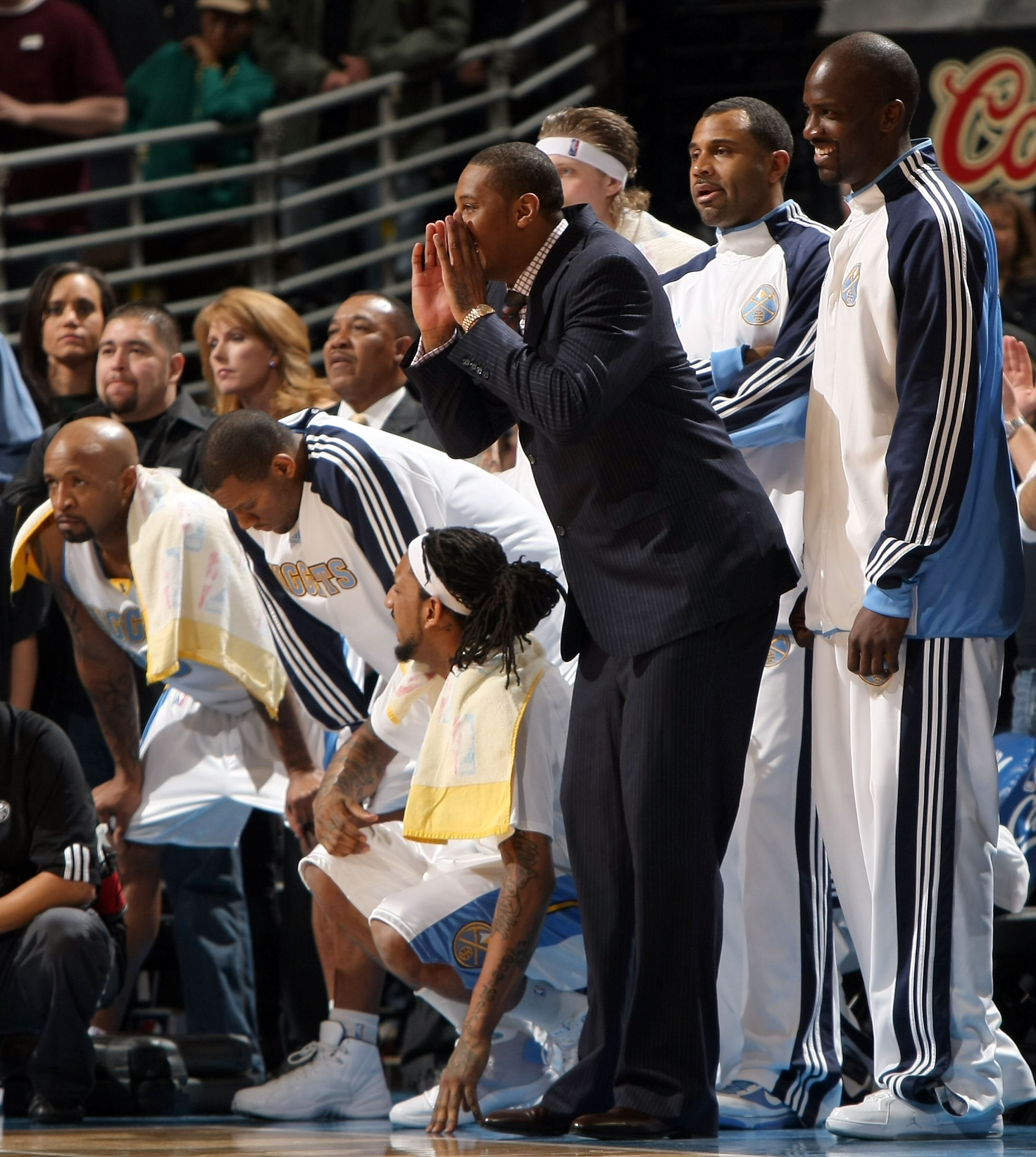 DENVER - JANUARY 08:  Carmelo Anthony #15 of the Denver Nuggets supports his team from the center of the bench in his street clothes against the Cleveland Cavaliers during NBA action at Pepsi Center on January 8, 2010 in Denver, Colorado. The Nuggets defe