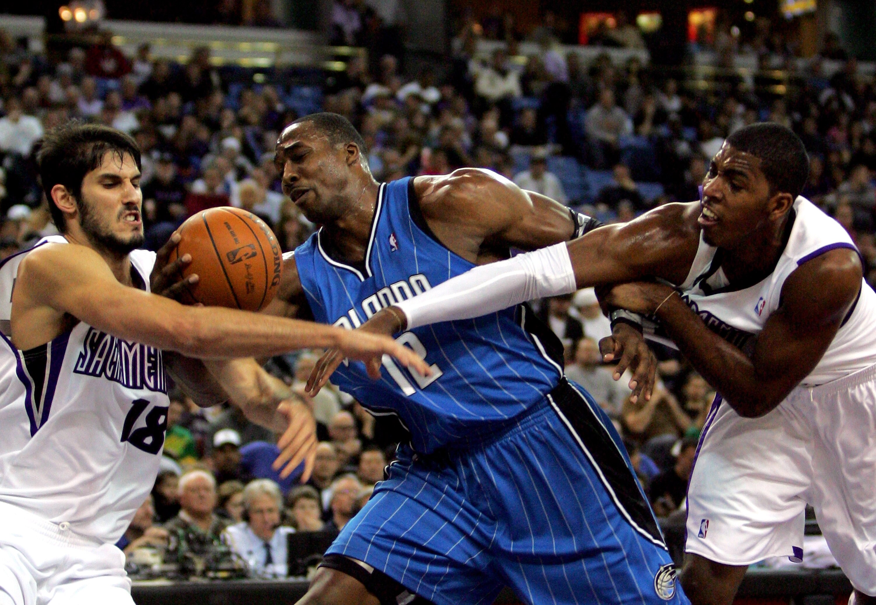SACRAMENTO, CA - JANUARY 12:  Dwight Howard #12 of the Orlando Magic gets tangled with Omri Casspi #18 and Jason Thompson #34 of the Sacramento Kings at ARCO Arena on January 12, 2010 in Sacramento, California.  NOTE TO USER: User expressly acknowledges a