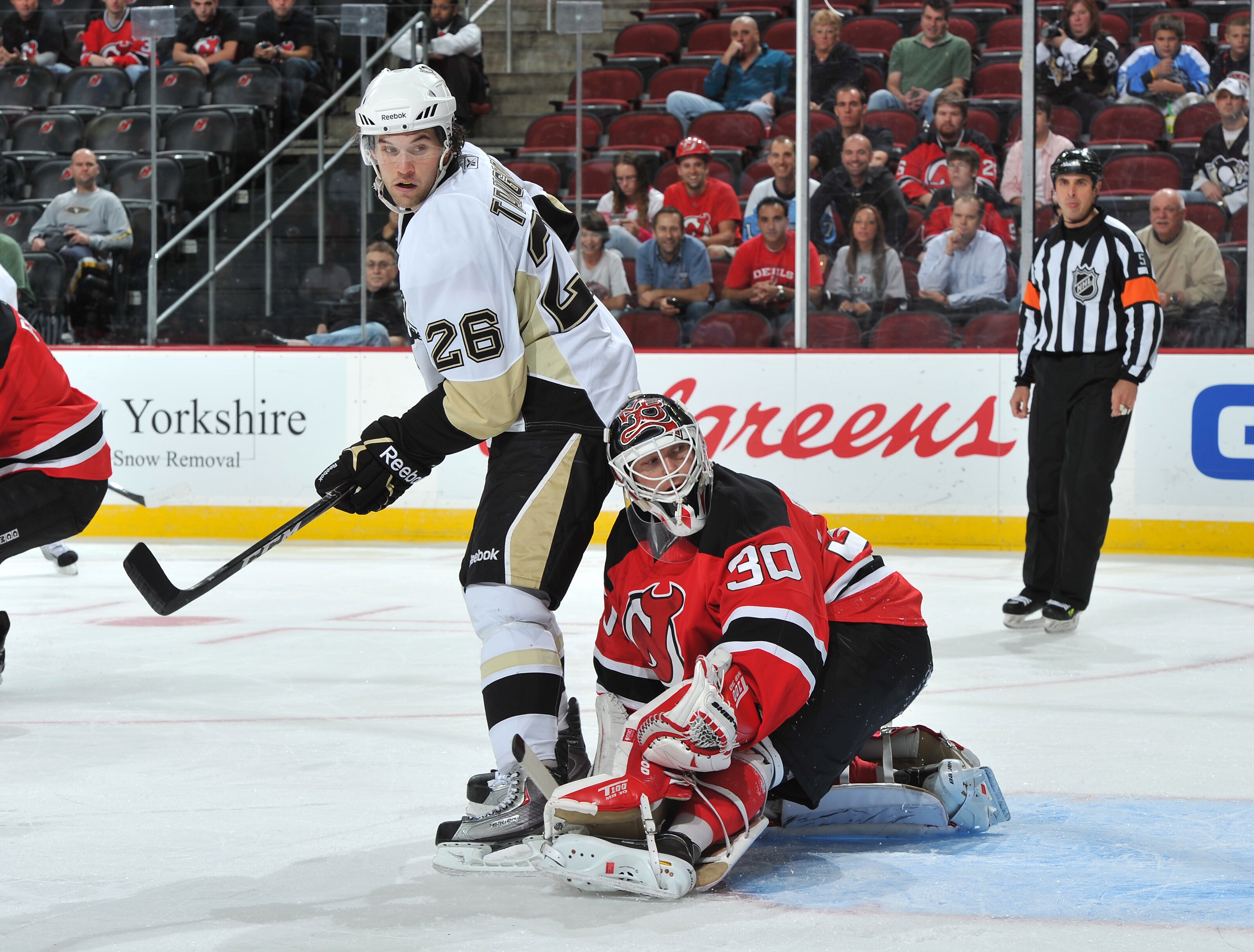 NEWARK, NJ - OCTOBER 11: Eric Tangradi  #26 of the Pittsburgh Penguins and Martin Brodeur #30 of the New Jersey Devils look back at a deflects shot on goal during the first period at the Prudential Center on October 11, 2010 in Newark, New Jersey. The Pen