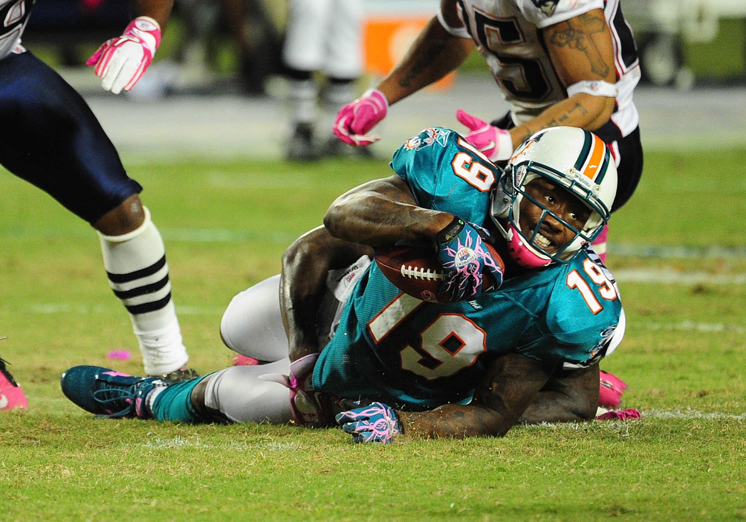 MIAMI - OCTOBER 4: Brandon Marshall #19 of the Miami Dolphins is tackled by Kyle Arrington #27 of the New England Patriots at Sun Life Field on October 4, 2010 in Miami, Florida. (Photo by Scott Cunningham/Getty Images)