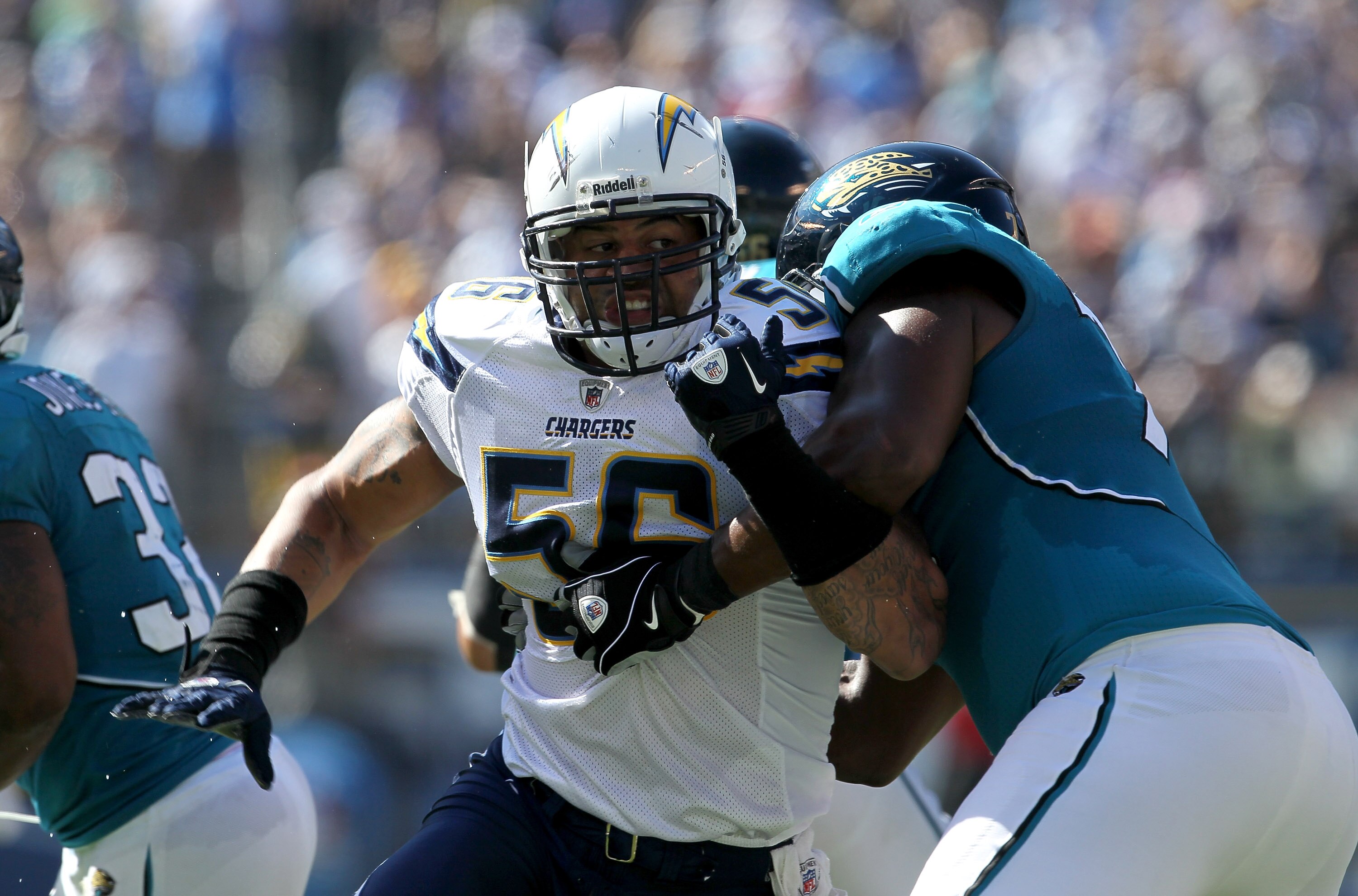 SAN DIEGO - SEPTEMBER 19:  Linebacker Shawne Merriman #56 of the San Diego Chargers fights against the block of tackle Eugene Monroe #75 of the Jacksonville Jaguars at Qualcomm Stadium on September 19, 2010 in San Diego, California. The Chargers won 38-13