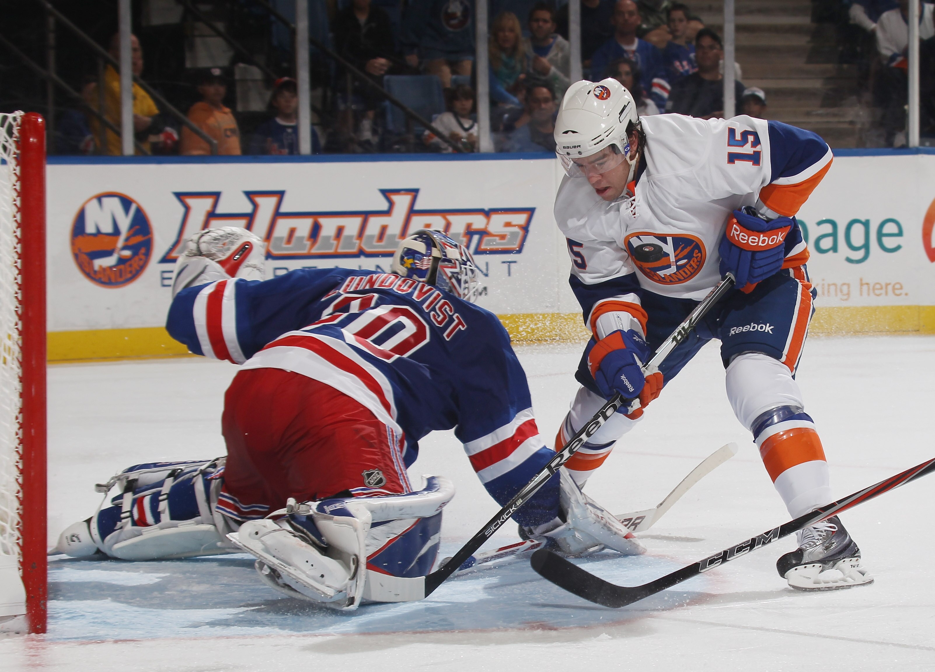 UNIONDALE, NY - OCTOBER 11: PA Parenteau #15 of the New York Islanders has the puck deflect off goaltender Henrik Lundqvist #30 of the New York Rangers and into his chest at the Nassau Coliseum on October 11, 2010 in Uniondale, New York. (Photo by Bruce B