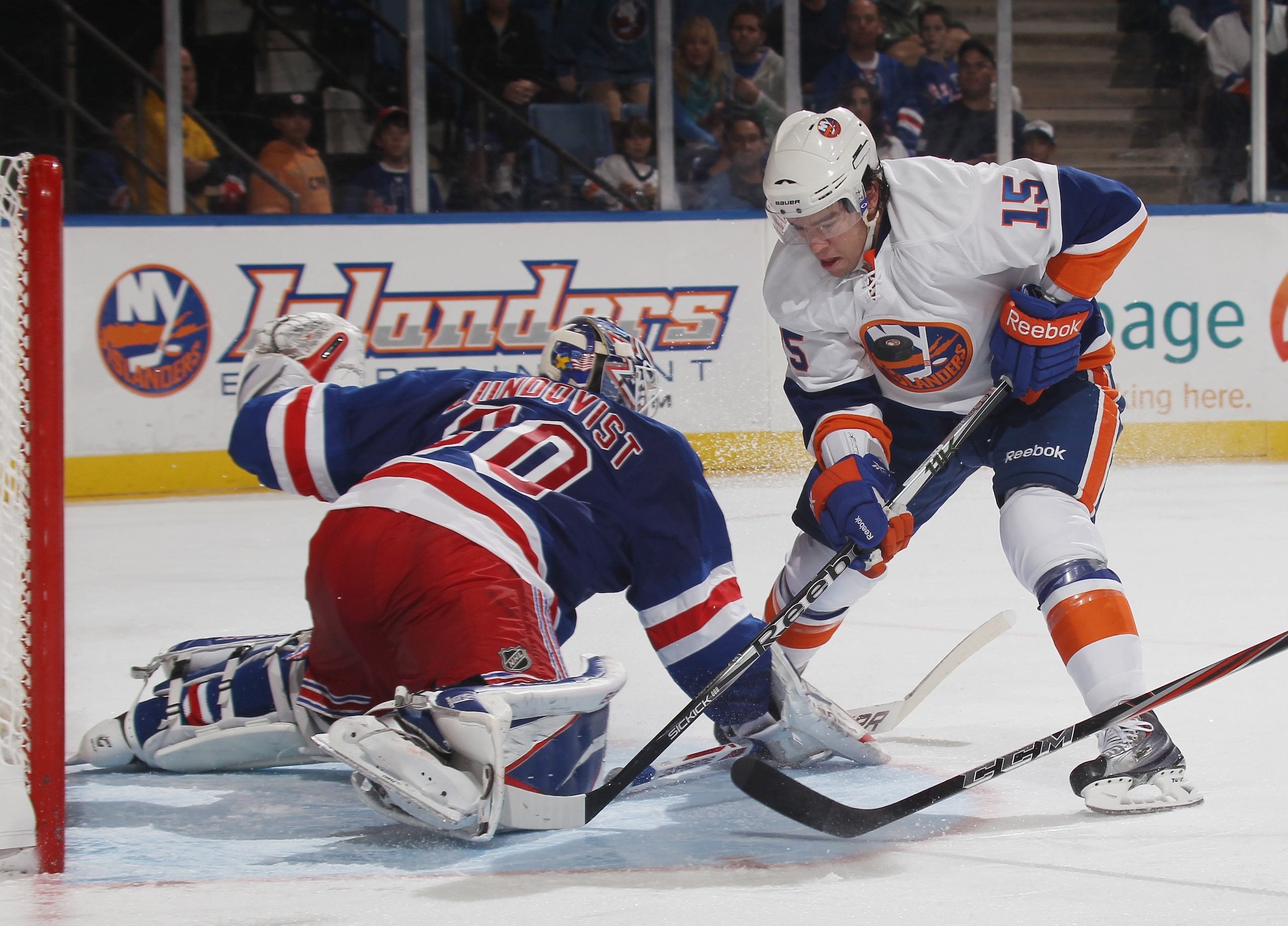 UNIONDALE, NY - OCTOBER 11: PA Parenteau #15 of the New York Islanders has the puck deflect off goaltender Henrik Lundqvist #30 of the New York Rangers and into his chest at the Nassau Coliseum on October 11, 2010 in Uniondale, New York. (Photo by Bruce B