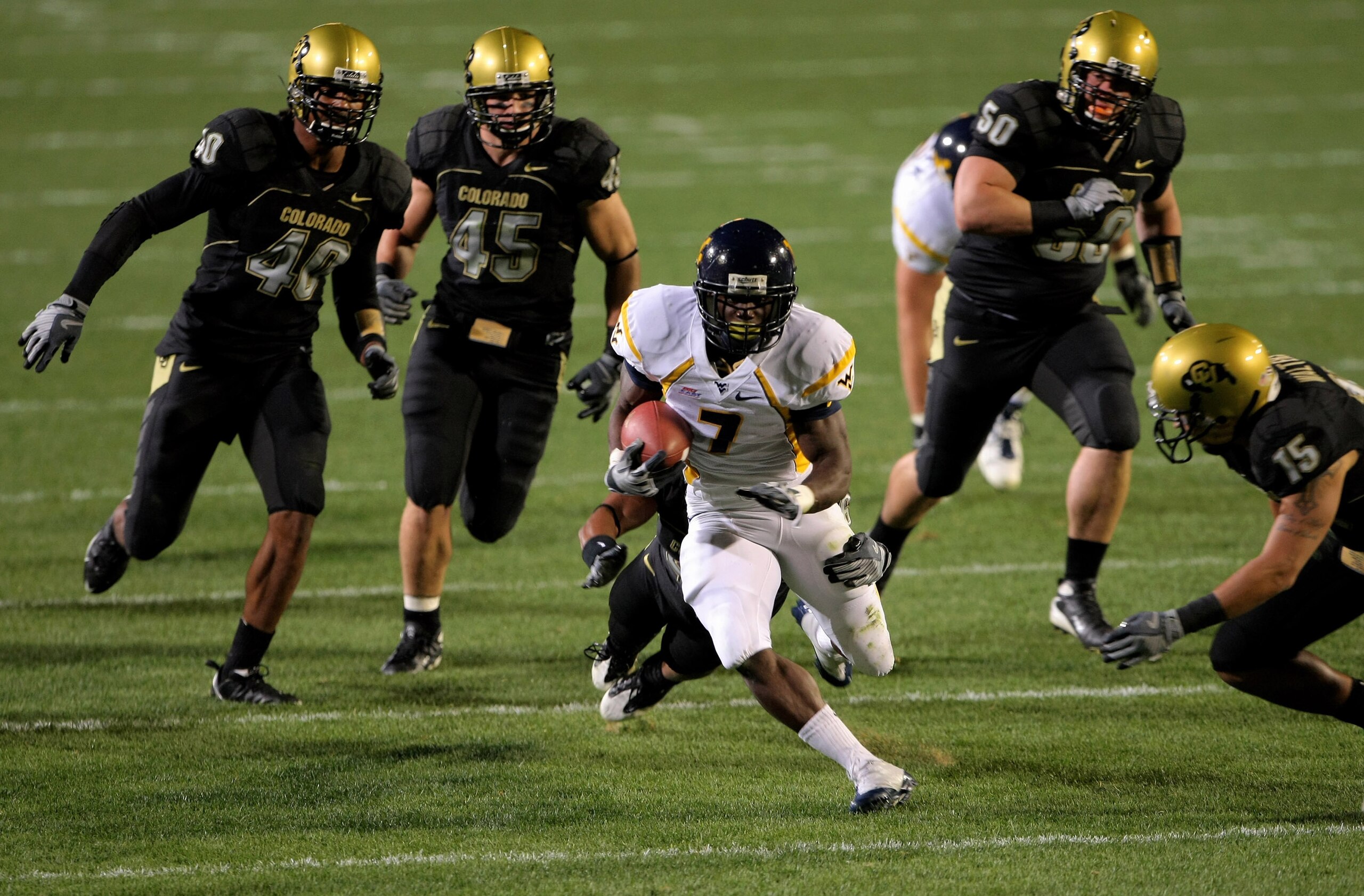 BOULDER, CO - SEPTEMBER 18:  Running back Noel Devine #7 of the West Virginia Mountaineers tries to elude the Colorado Buffaloes defense at Folsom Field September 18, 2008 in Boulder, Colorado. Colorado defeated West Virginia 17-14 in overtime.  (Photo by