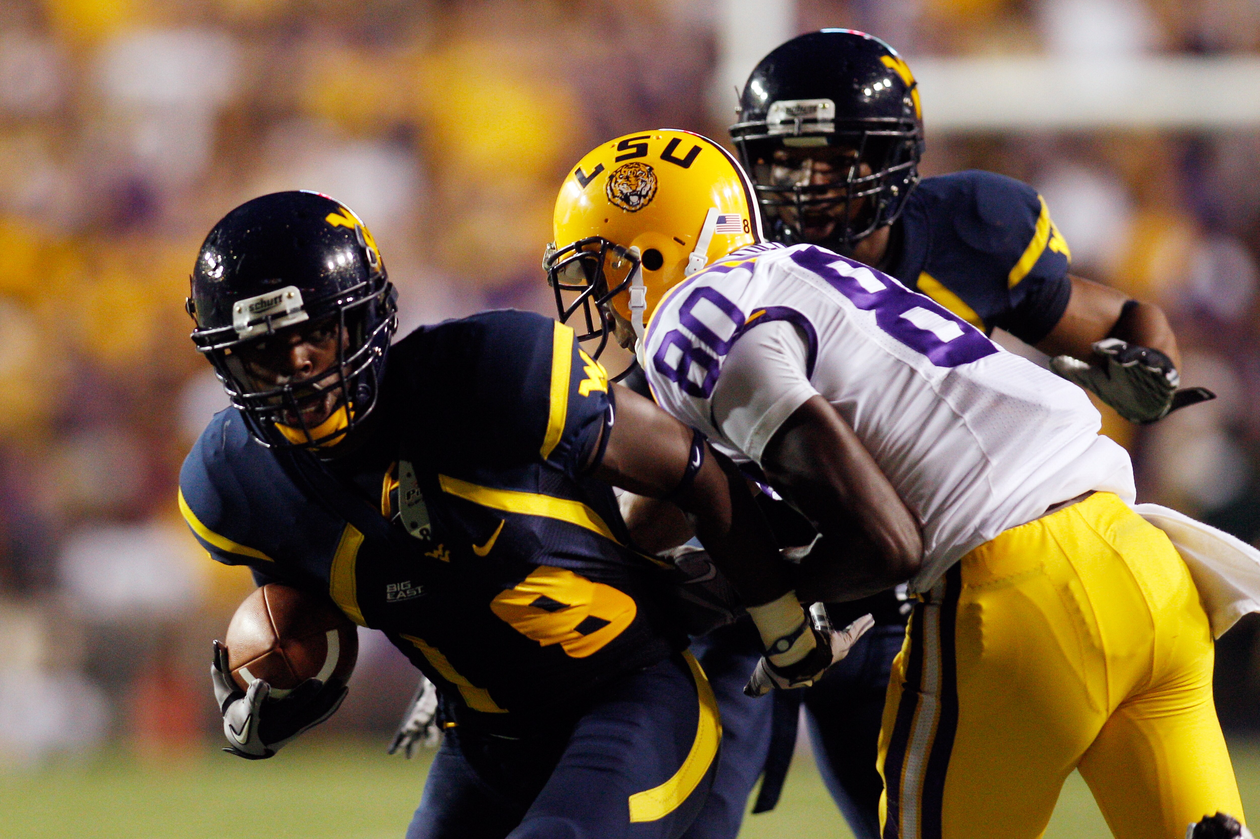 BATON ROUGE, LA - SEPTEMBER 25: Keith Tandy #8  of the West Virginia Mountaineers is tackled after intercepting the ball by Terrence Toliver #80  of the Louisiana State Univeristy Tigers at Tiger Stadium on September 25, 2010 in Baton Rouge, Louisiana.  (