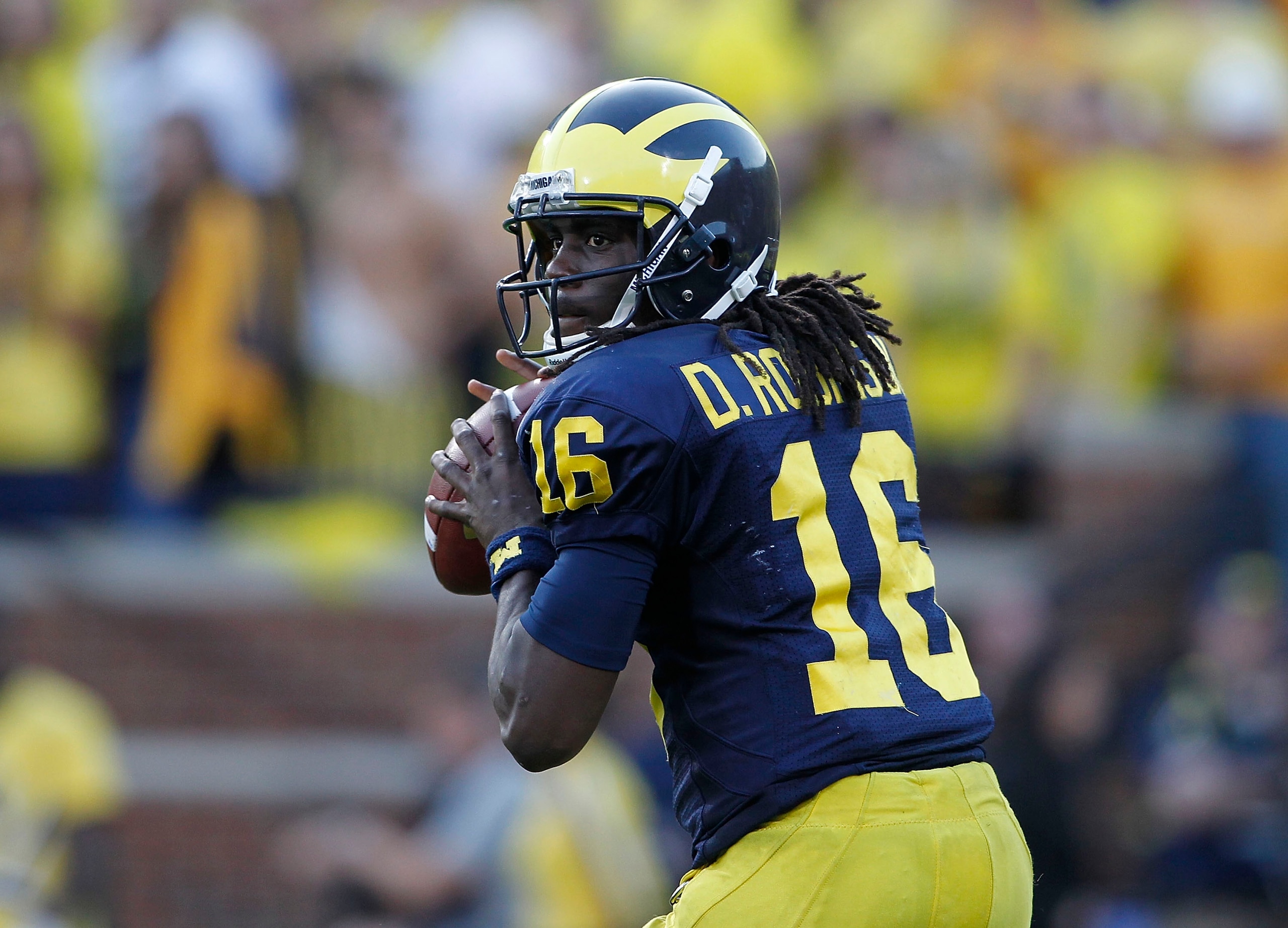 ANN ARBOR, MI - OCTOBER 09: Denard Robinson #16 of the Michigan Wolverines drops back to pass during the game against the Michigan State Spartans on October 9, 2010 at Michigan Stadium in Ann Arbor, Michigan. The Michigan State Spartans defeated the Mich ANN ARBOR, MI - OCTOBER 09: Denard Robinson #16 of the Michigan Wolverines drops back to pass during the game against the Michigan State Spartans on October 9, 2010 at Michigan Stadium in Ann Arbor, Michigan. The Michigan State Spartans defeated the Mich